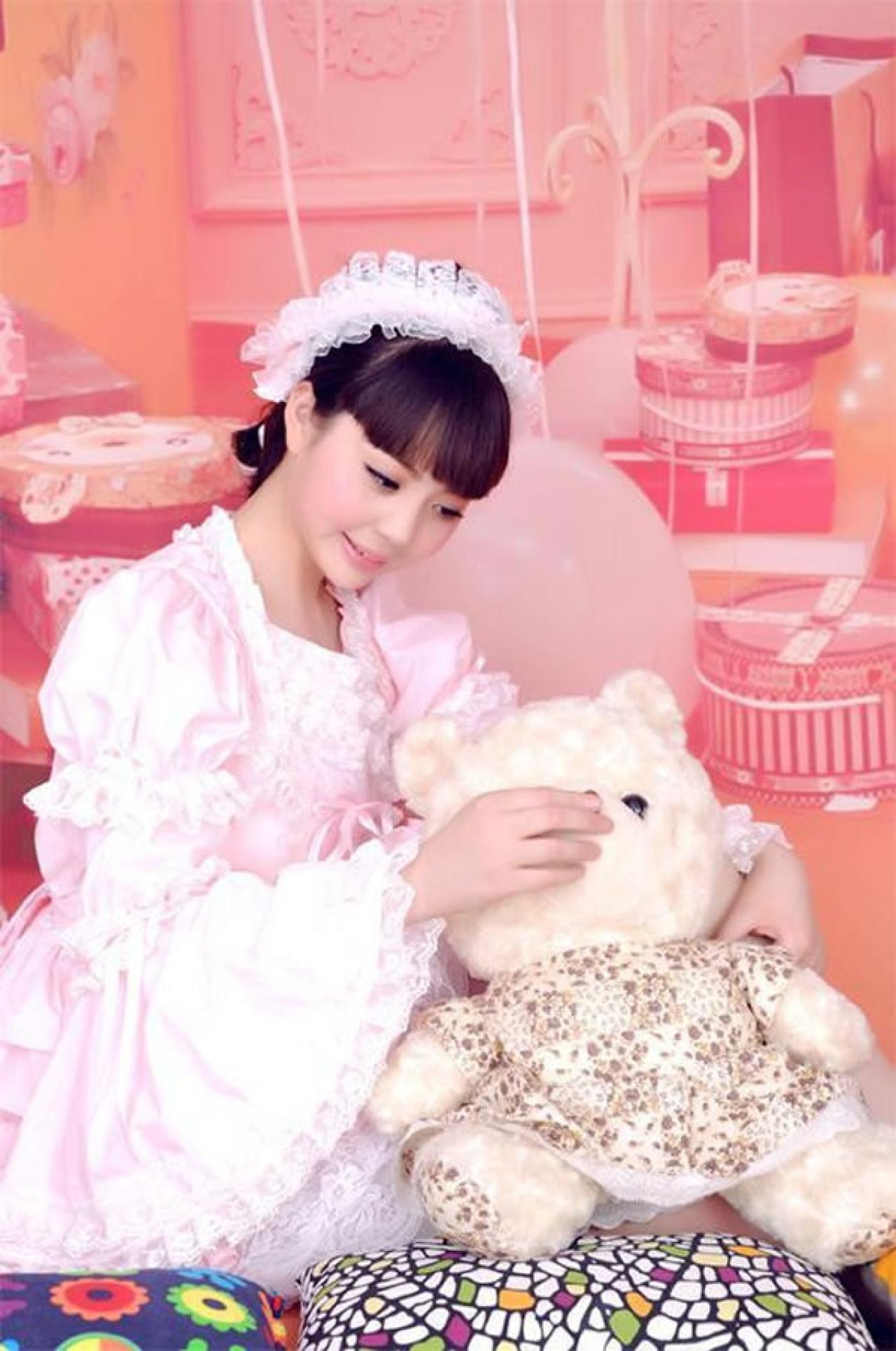 魔法少女大道寺知世穿着粉色公主裙坐在地上，抚摸毛绒小熊的姿势