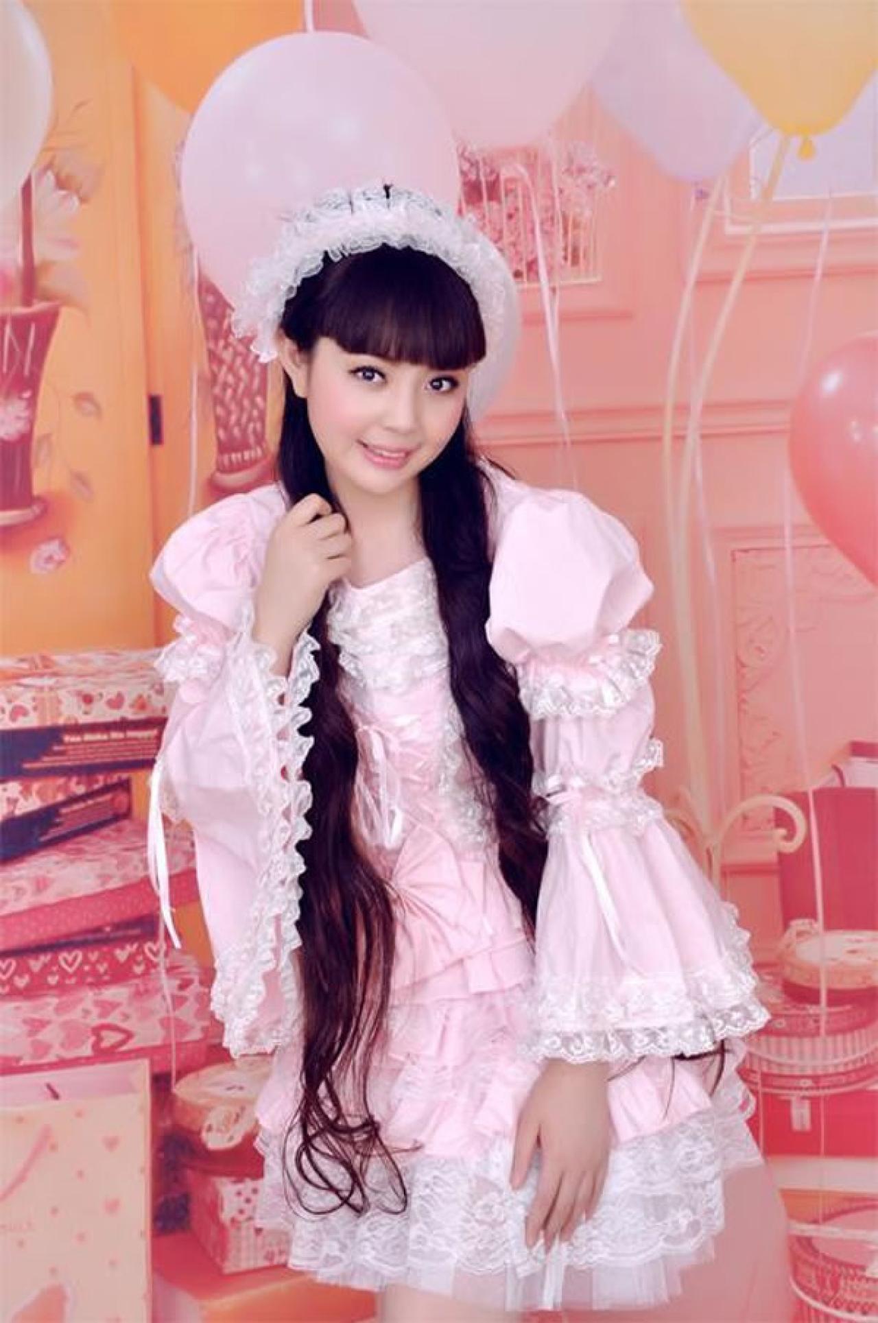 魔法少女大道寺知世穿着粉色公主裙一手自然下摆，一手抚摸头发的姿势