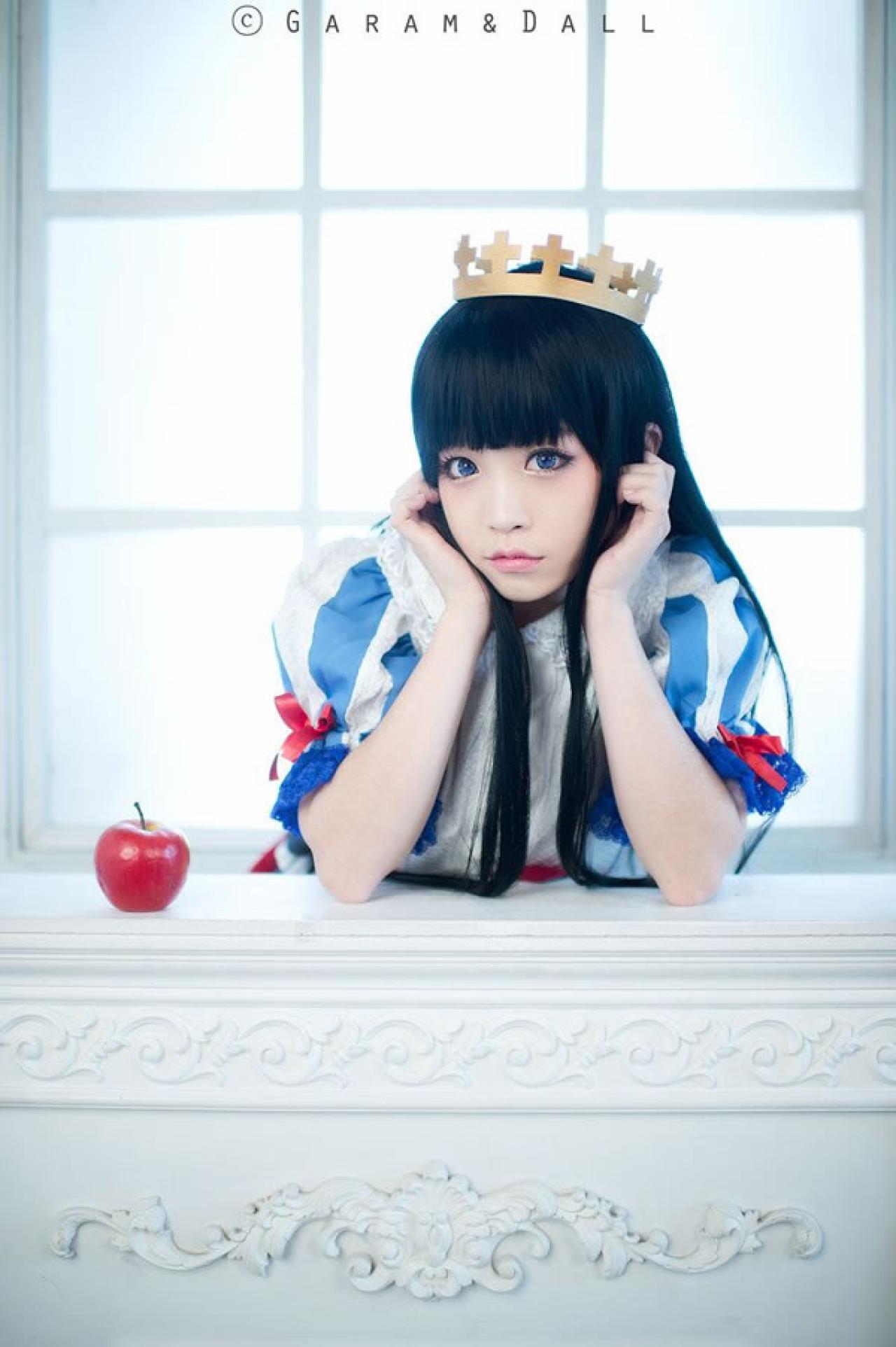 兔娘Tomia穿着蓝白洋装扮演白雪公主扶在桌子上，双手捧着脸陷入思考