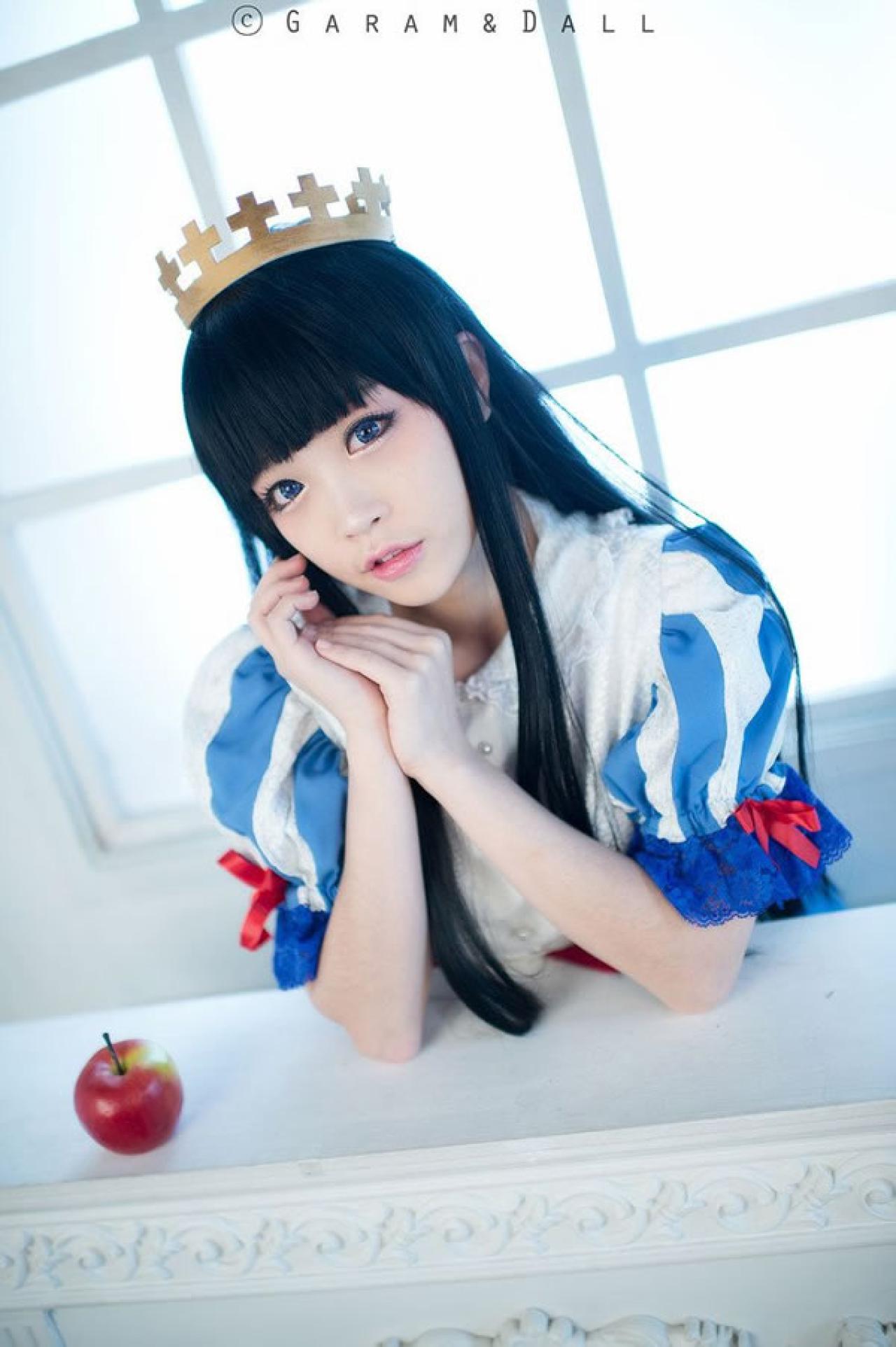 兔娘Tomia穿着蓝白洋装扮演白雪公主，一手撑在桌面，另一只手放在这只手的手心的样子