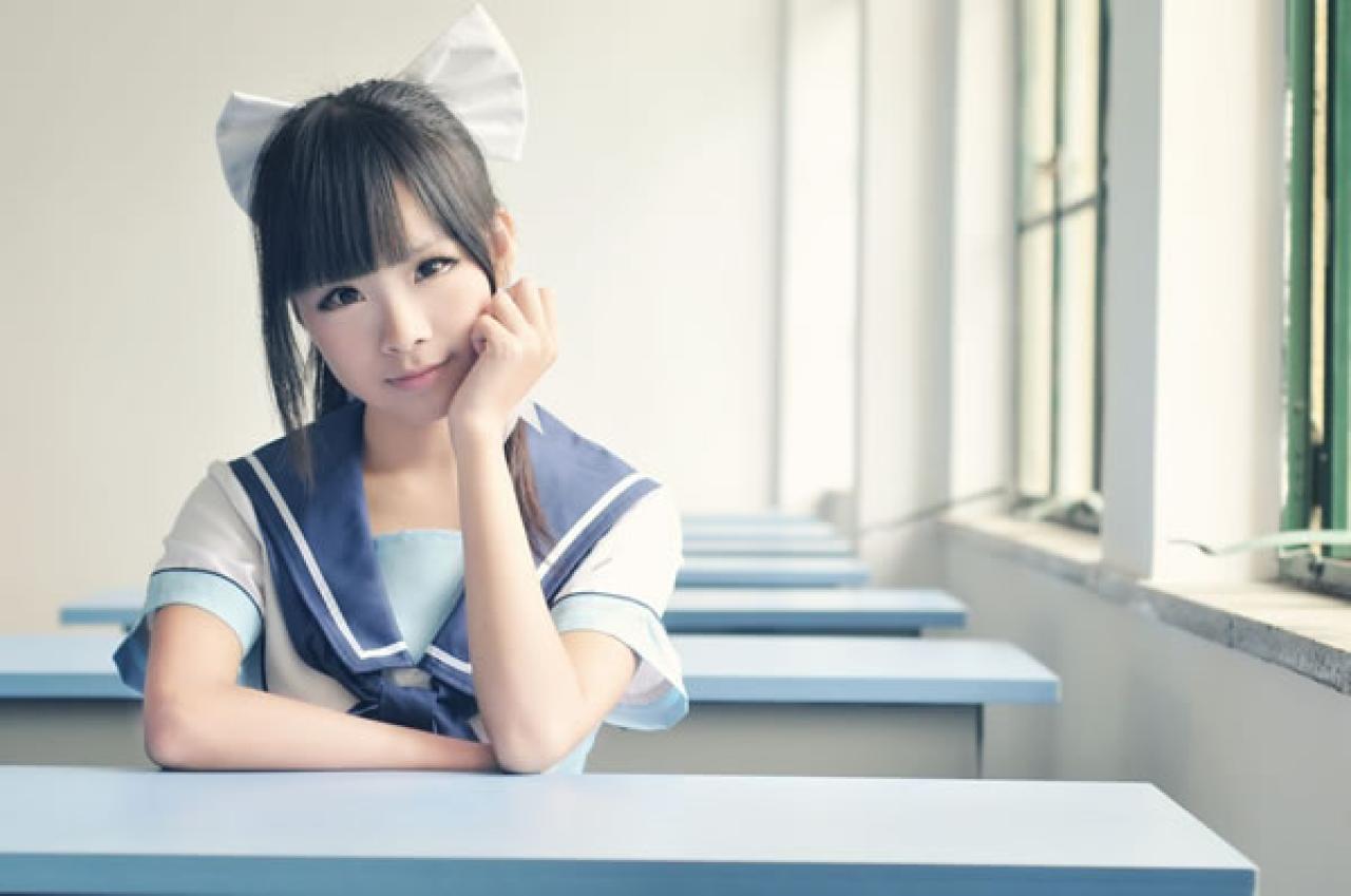 熊酱穿着蓝色学院校服扮演高岭爱花，趴在窗前的课桌上，单手撑起下巴