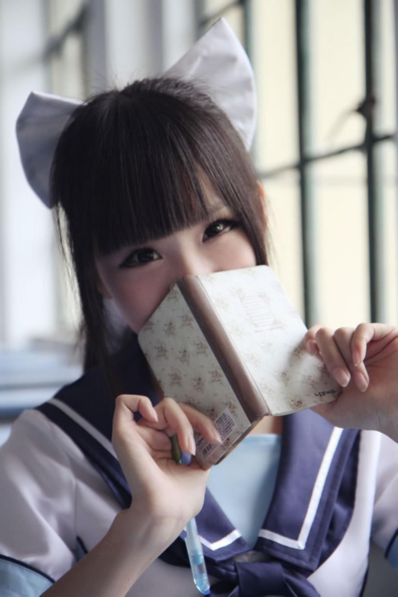 熊酱穿着蓝色学院校服扮演高岭爱花，用笔记本捂着嘴偷笑的样子