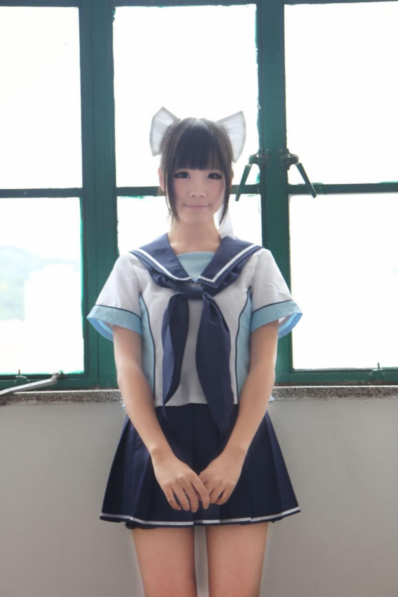 熊酱穿着蓝色学院校服扮演高岭爱花，两手下垂自然拉在一起，靠在窗台的样子