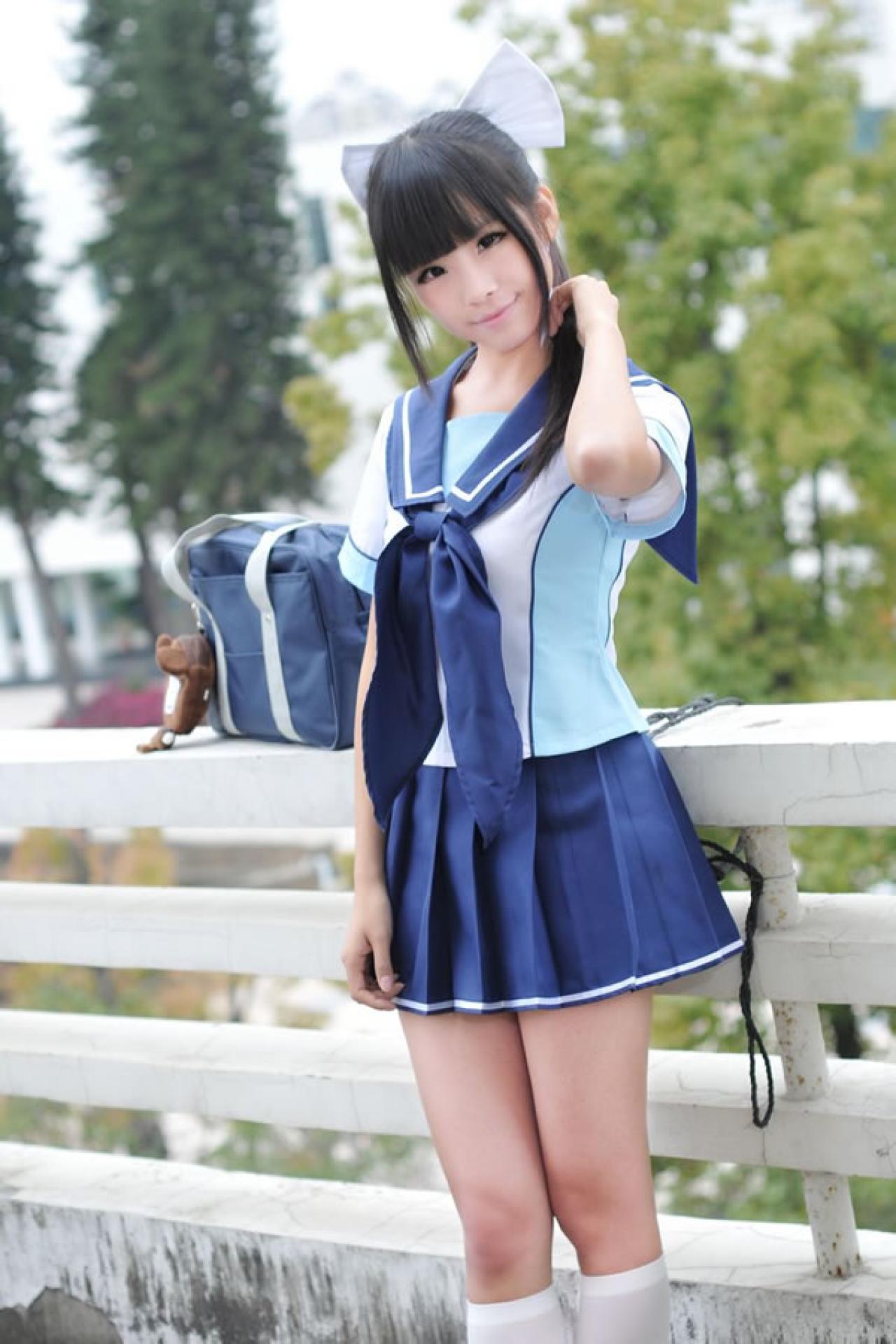 熊酱穿着蓝色学院校服扮演高岭爱花，把包放在天台的栏杆上，轻轻抚弄秀发的样子