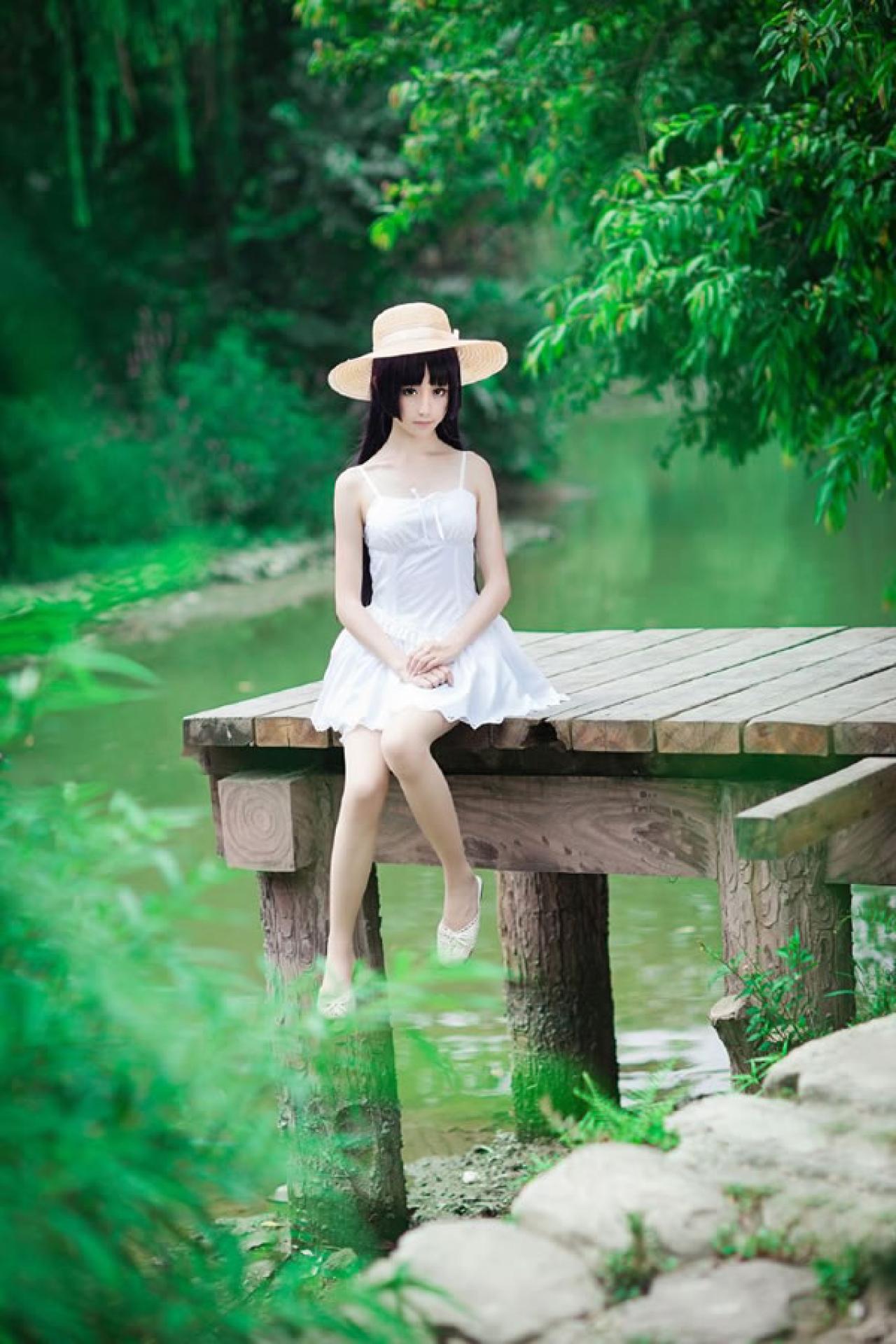 镜祭穿着白色连衣短裙扮演五更琉璃白猫，坐在木制码头上