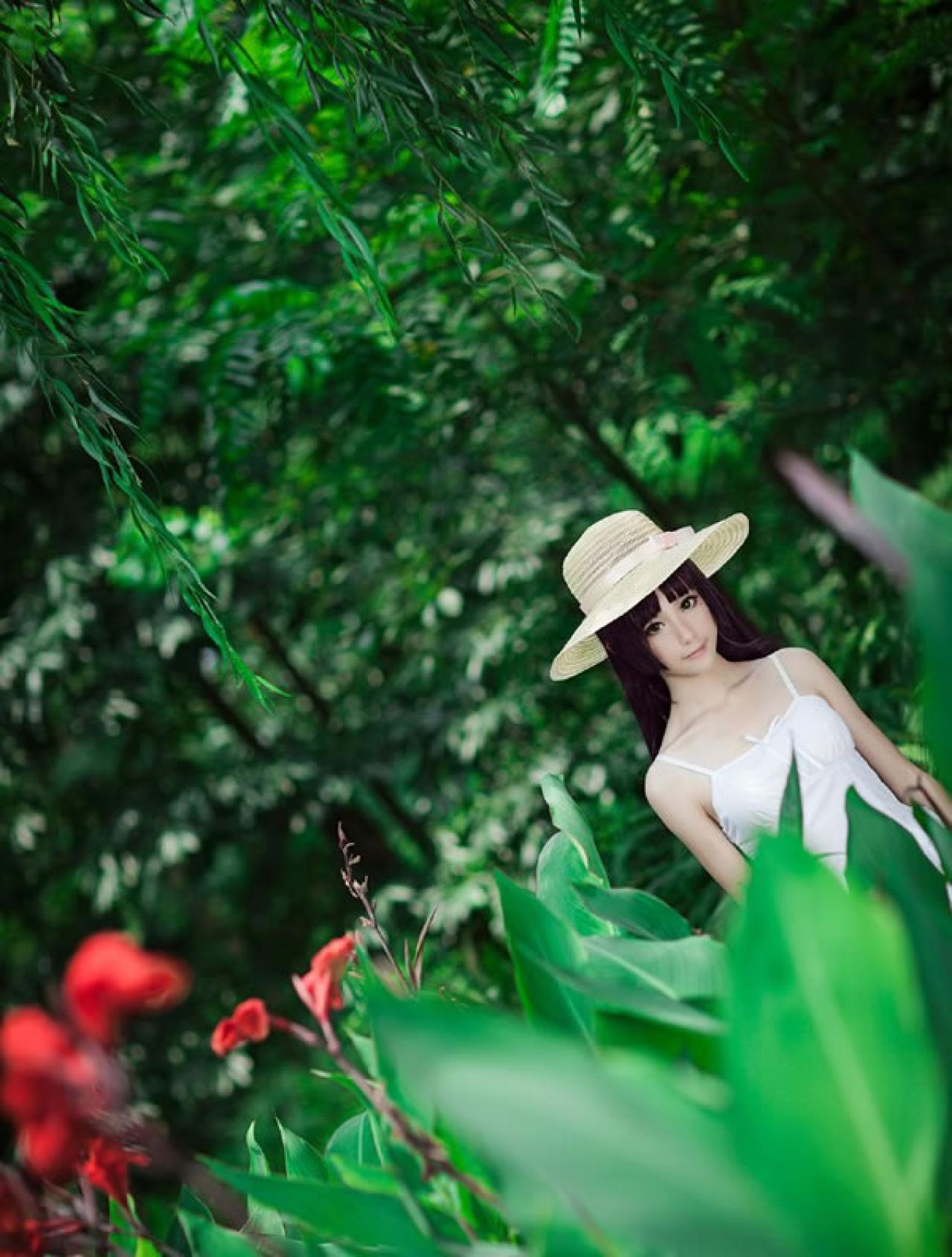 镜祭穿着白色连衣短裙扮演五更琉璃白猫，在绿色植物的衬托下的上半身照