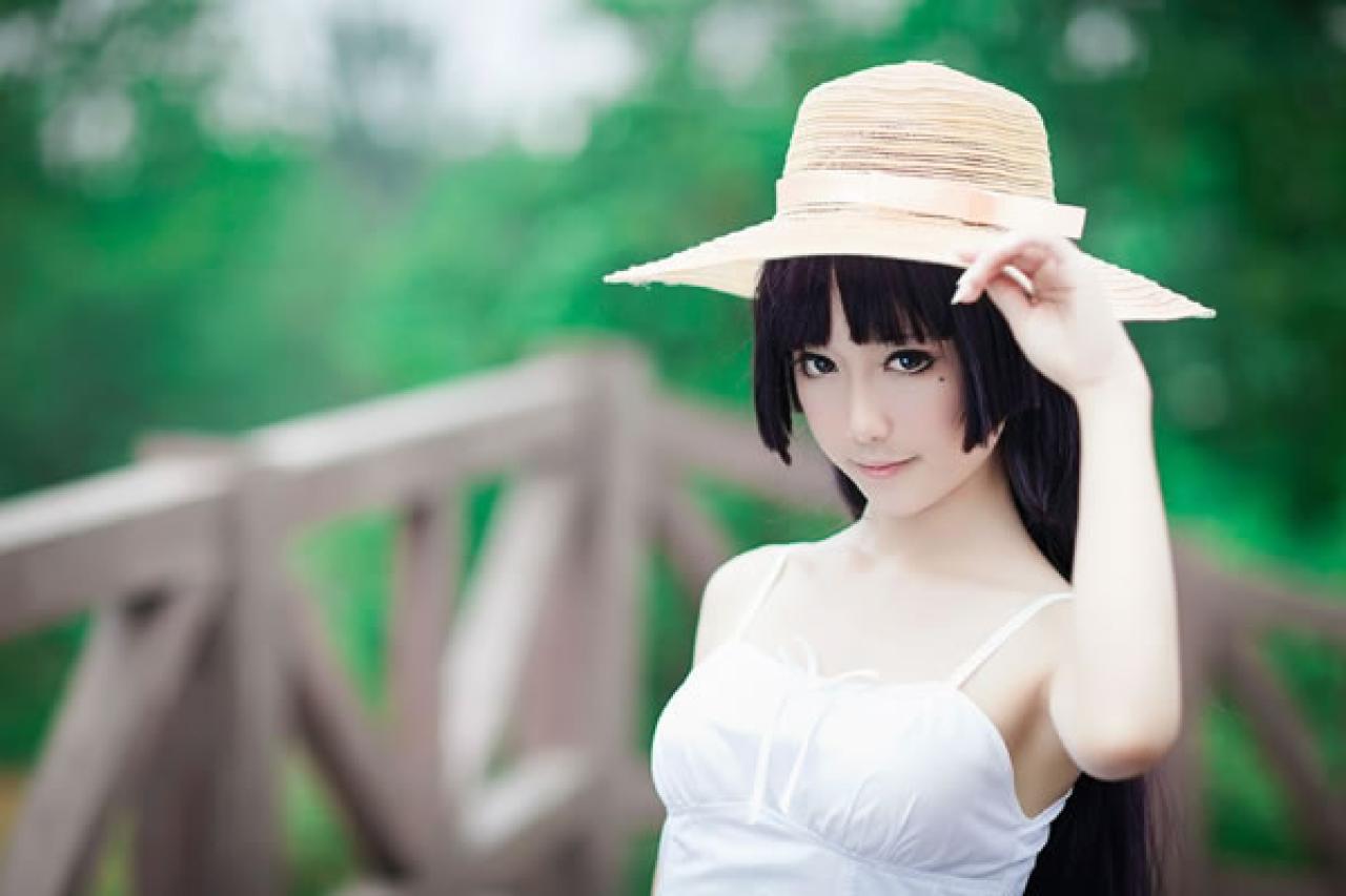 镜祭穿着白色连衣短裙扮演五更琉璃白猫，在木制栏杆的围角旁，扶着太阳帽的正面照