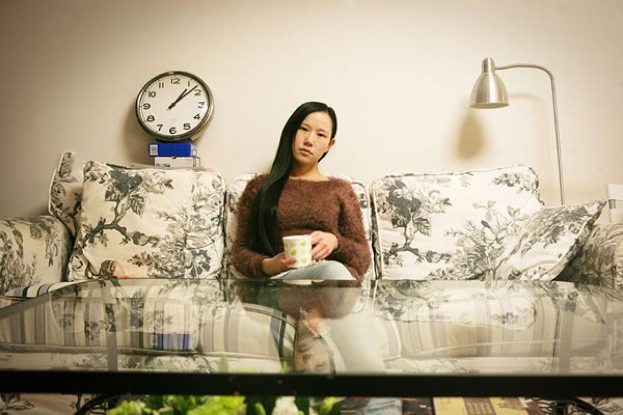 晚上回到北京的出租屋里，90后Showgirl王可欣坐在沙发上疲倦的样子