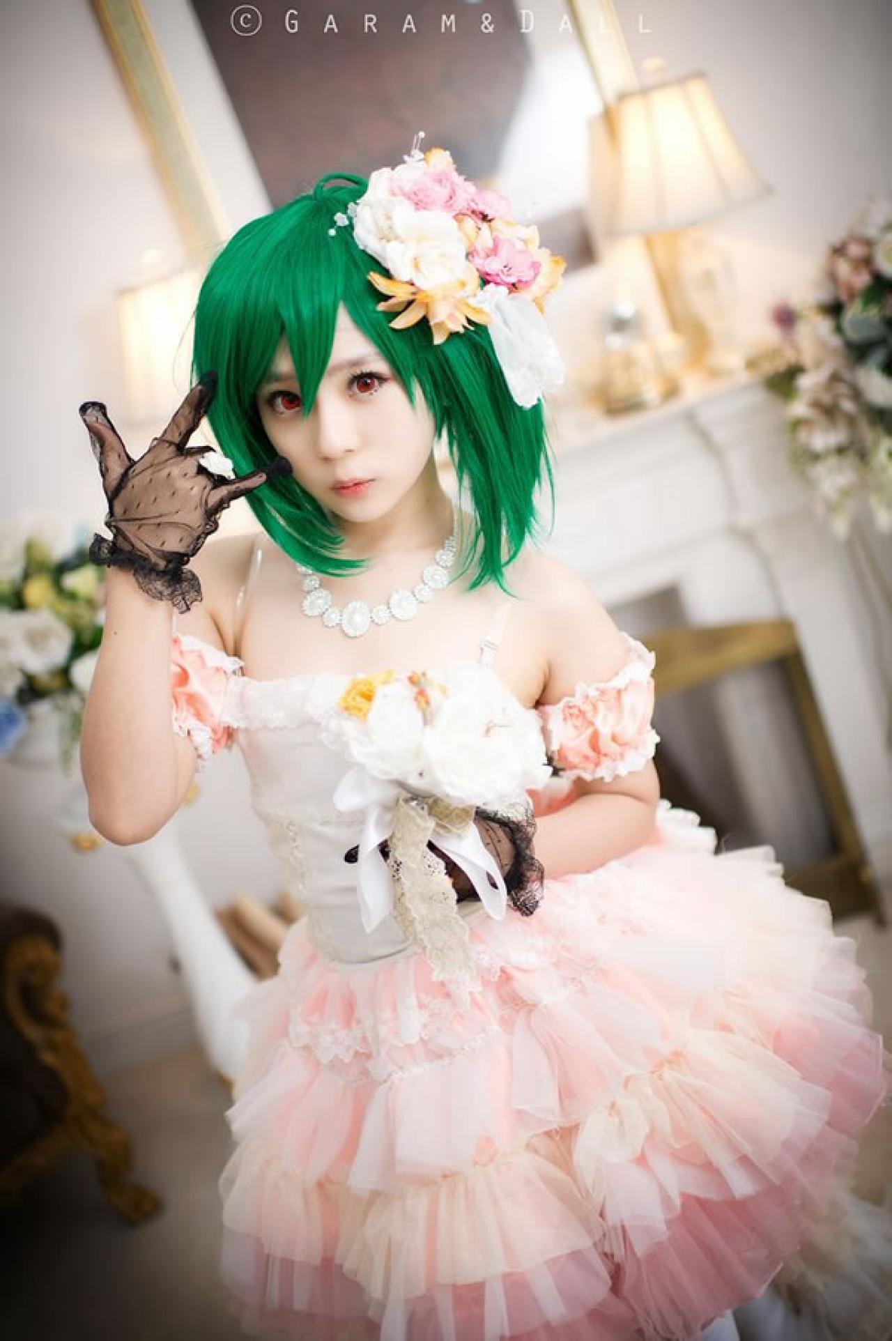 粉色洋装的兰歌·李身旁捧着鲜花捧着鲜花，手指轻抚脸庞正面