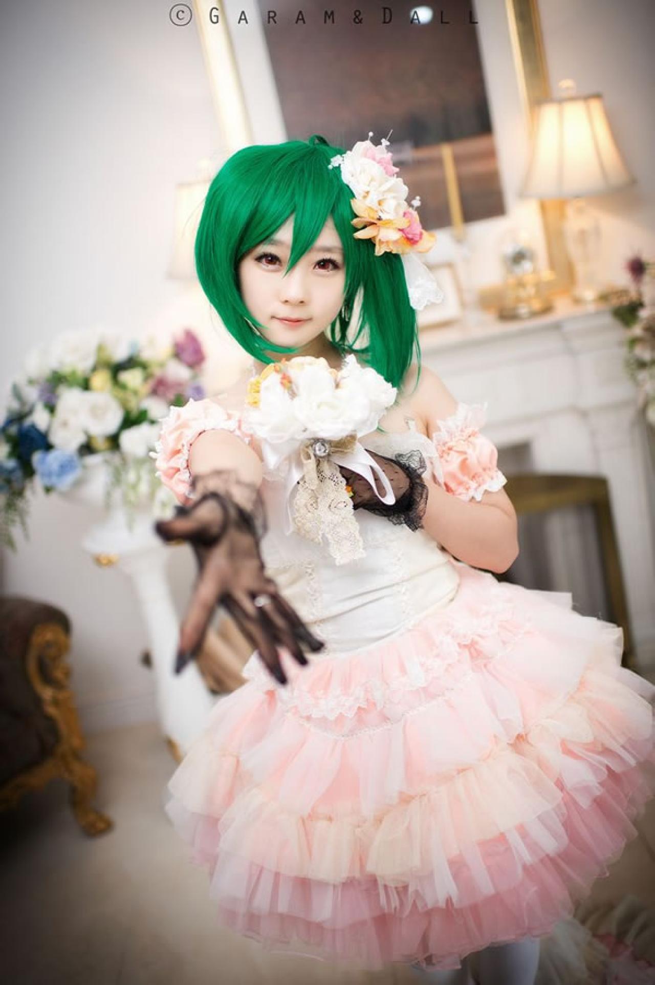 粉色洋装的兰歌·李身旁捧着鲜花伸出手正面