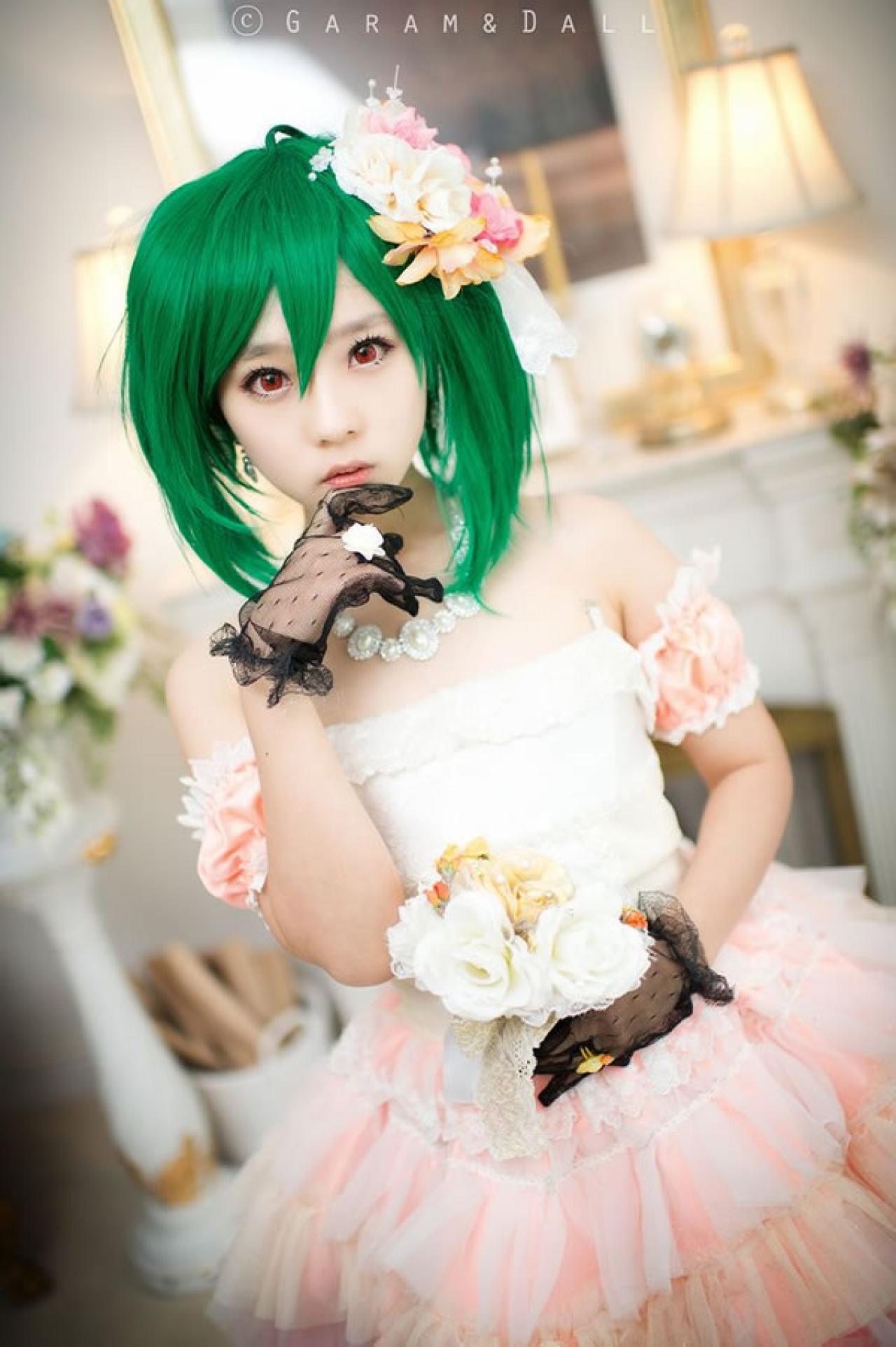 粉色洋装的兰歌·李身旁捧着鲜花轻抚下巴