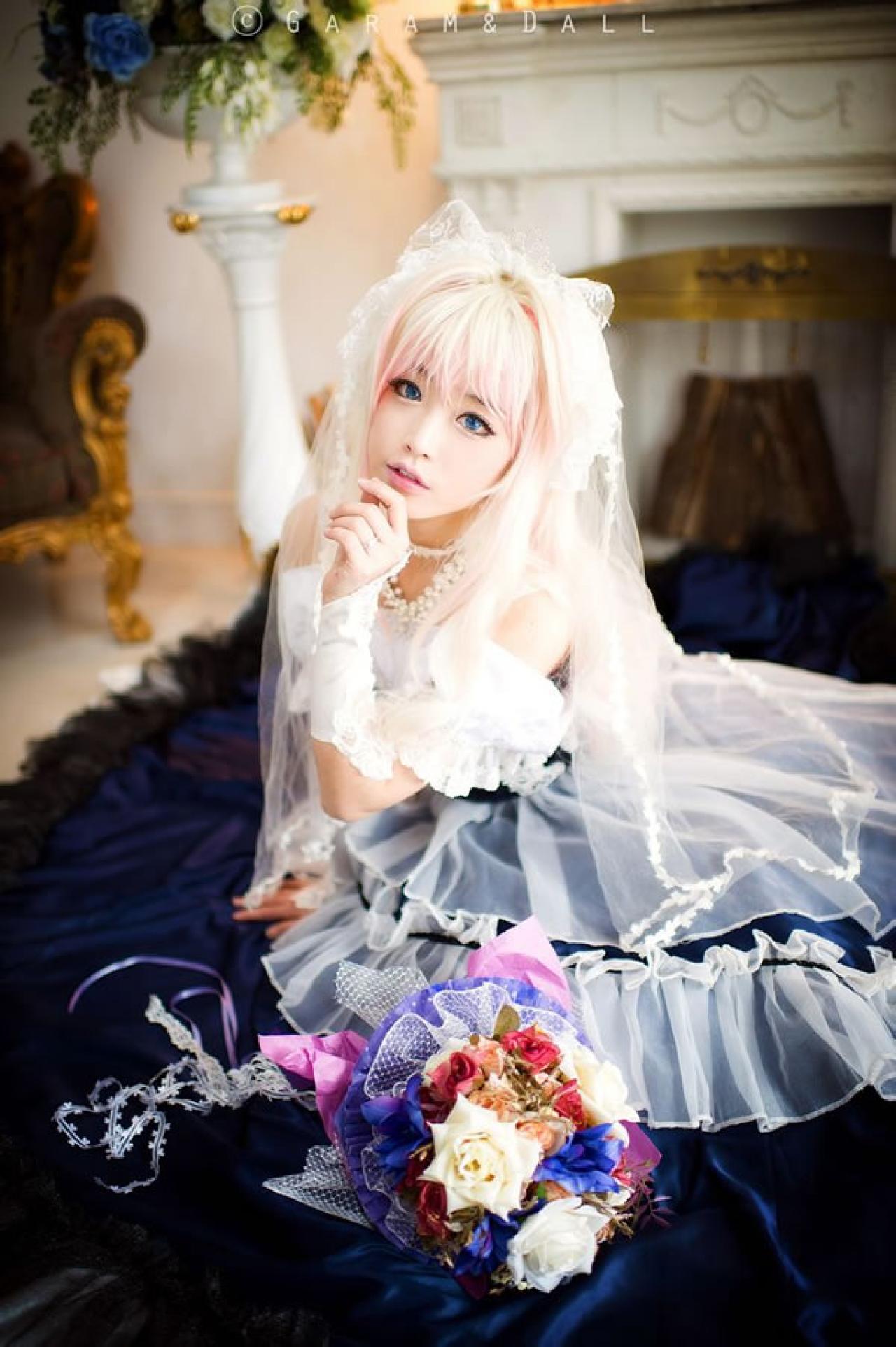 雪露·诺姆穿着蓝色洋装手指轻轻捏着下巴