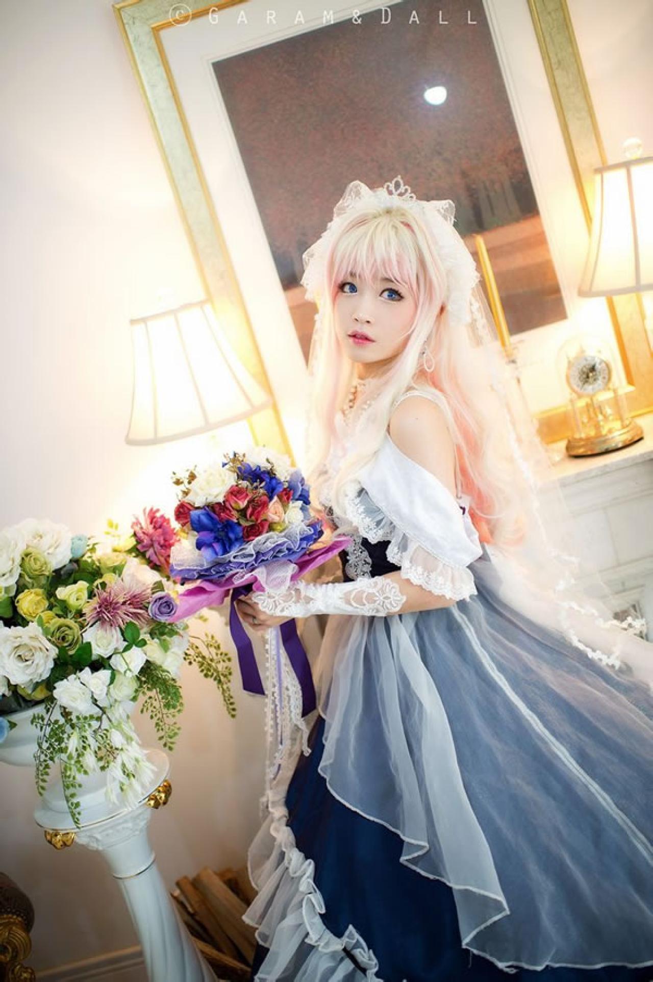 雪露·诺姆穿着蓝色洋装手捧鲜花侧面照