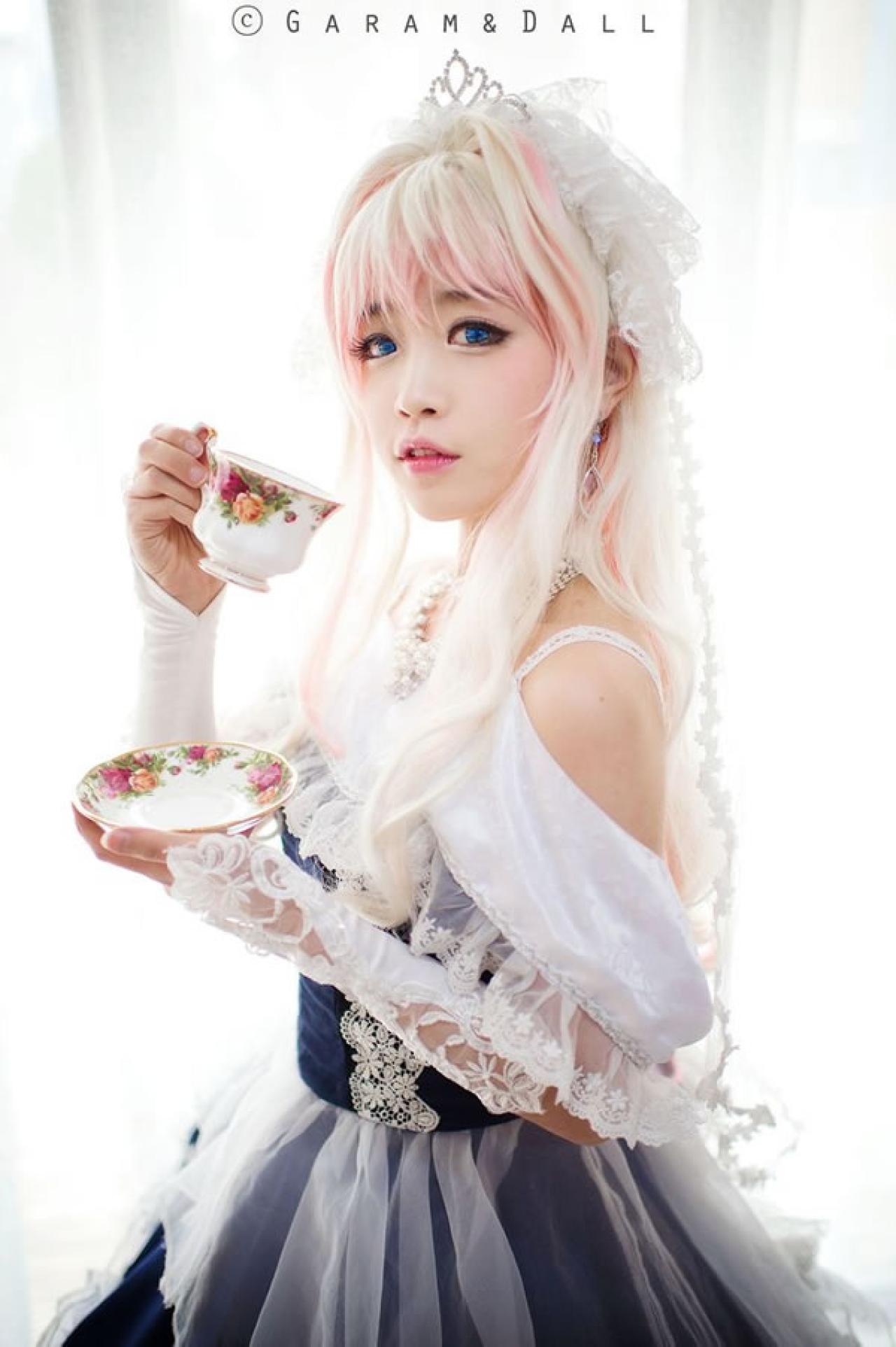 雪露·诺姆穿着蓝色洋装端着陶瓷花纹杯子侧面