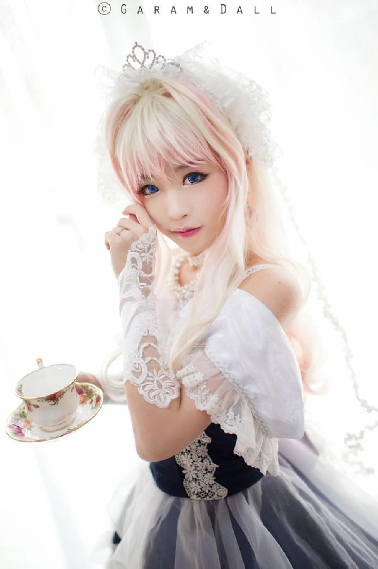 雪露·诺姆穿着蓝色洋装端着陶瓷花纹杯子，轻轻抚摸着鬓角