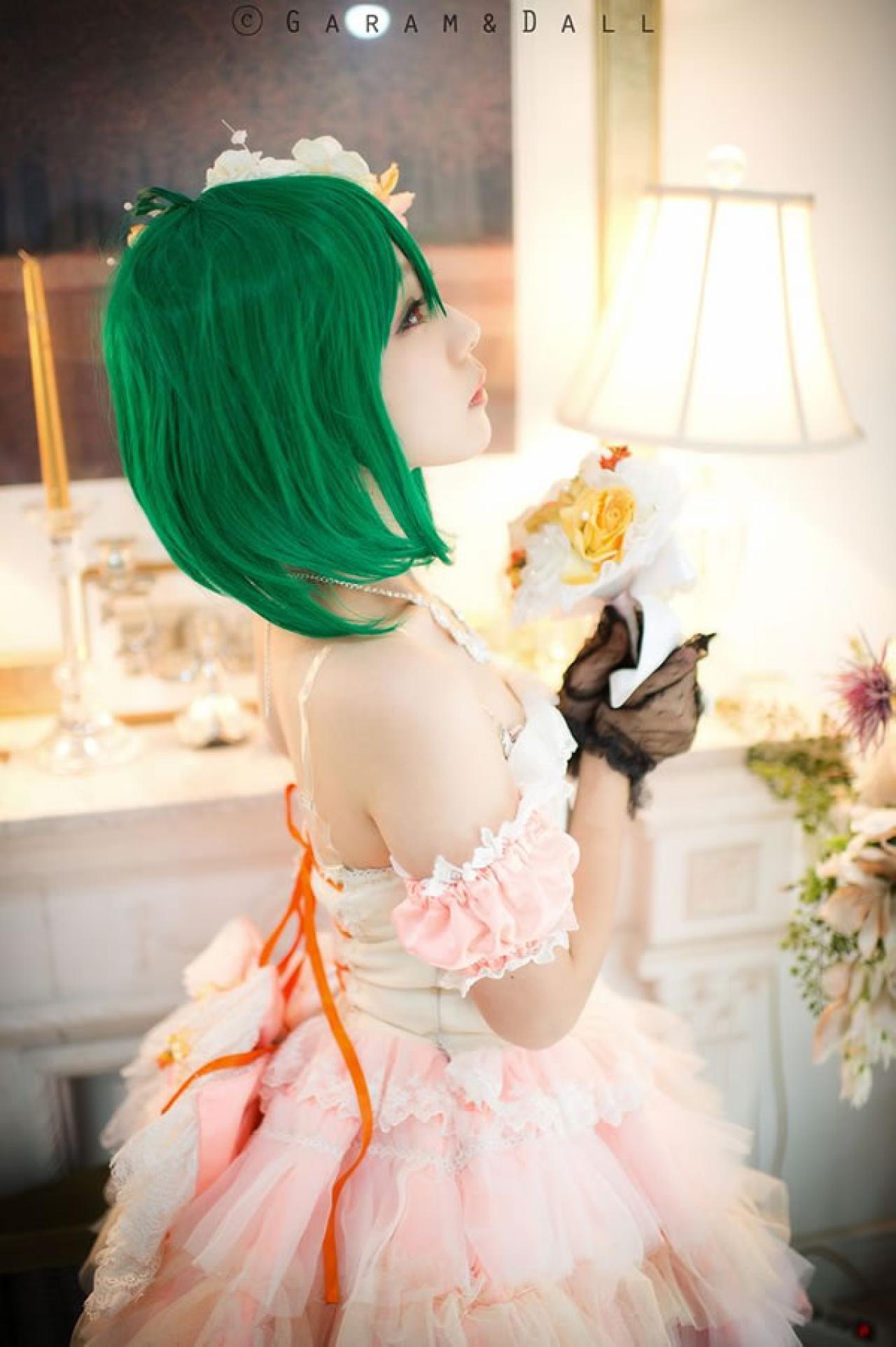 穿着粉色洋装的兰歌·李在梳妆台旁捧着鲜花的侧面