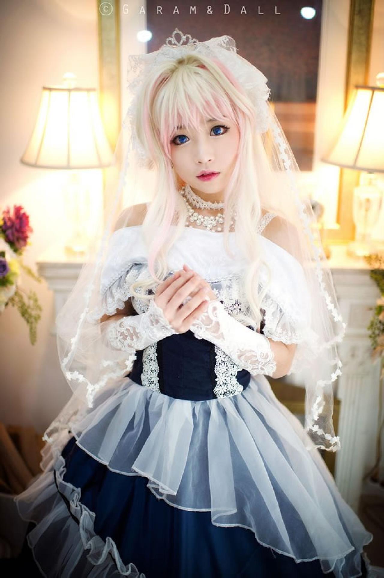 雪露·诺姆穿着蓝色洋装双手叠放在胸部站立