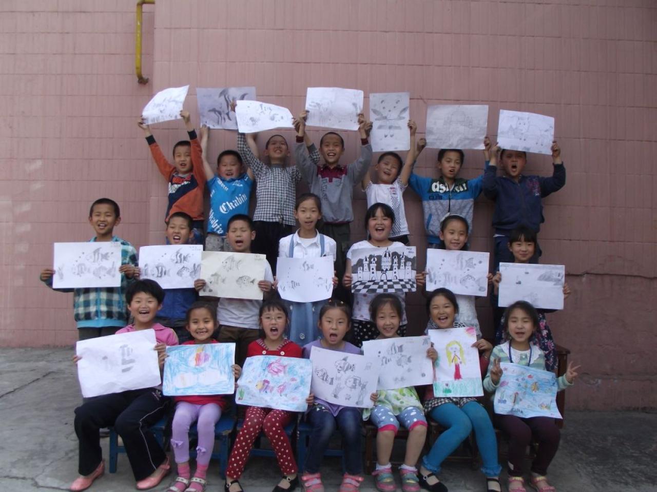 圆梦画室一部初级班的学生和他们的作品合影