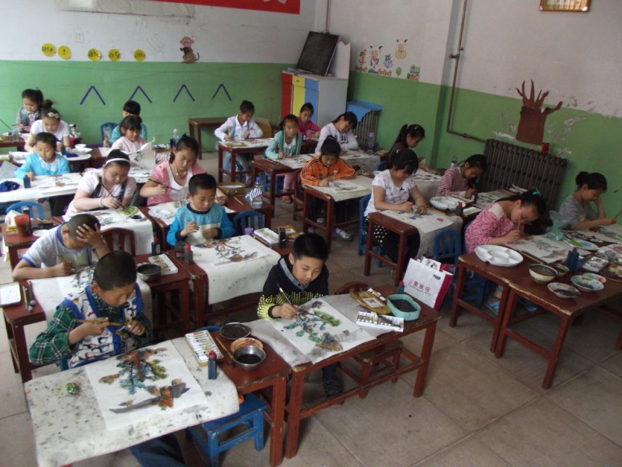 圆梦画室一部中级班的学生正在毡子上画国画