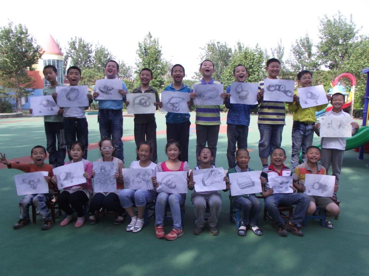 圆梦画室一部提高班的学生和他们的作品合影