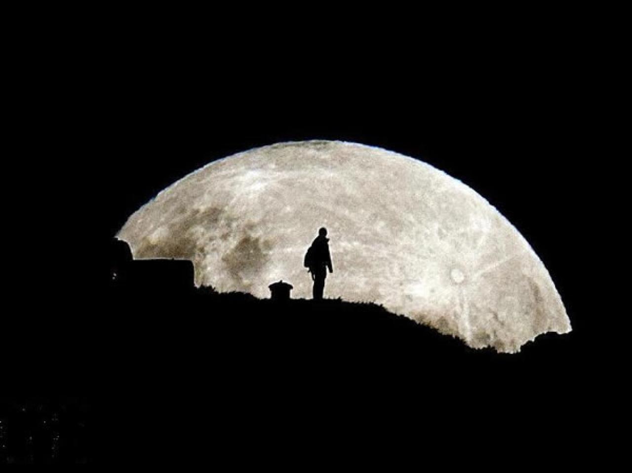 一位背包客眺望地平线上的月亮