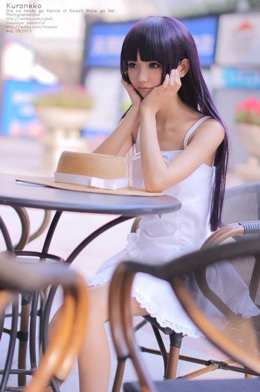 黑猫坐在圆桌旁，双手撑住脸庞发呆