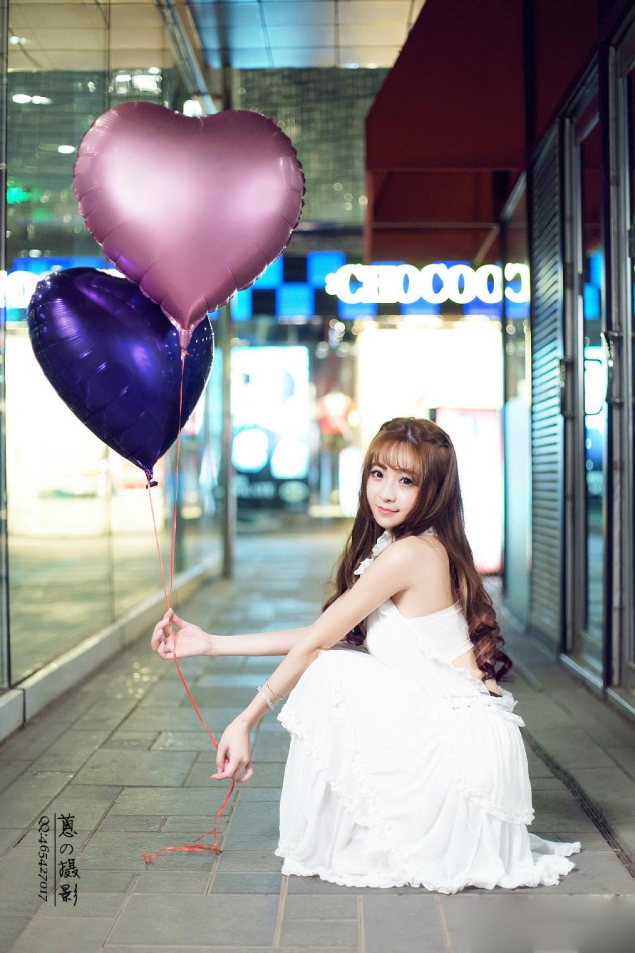 紫颜颜sweet手持气球蹲在地上