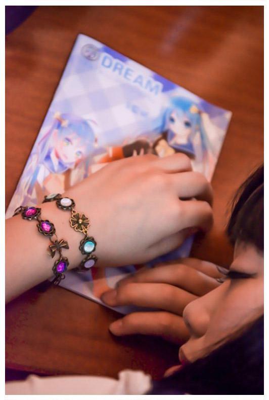 穿戴手链的夢社娘扒在桌子上，手链特写