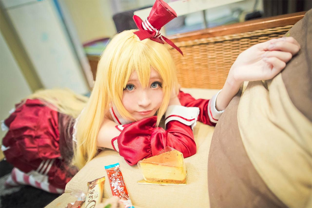 Meter扮演裘可拉趴在桌子上，桌上放着巧克力、蛋糕等零食。