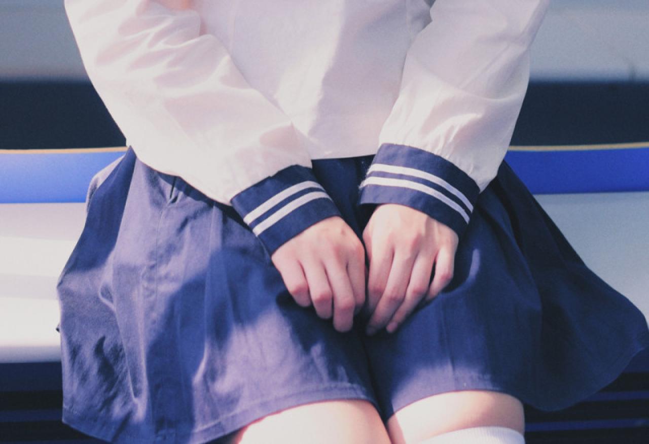 双马尾水手服少女两只手放在腿上，正面特写
