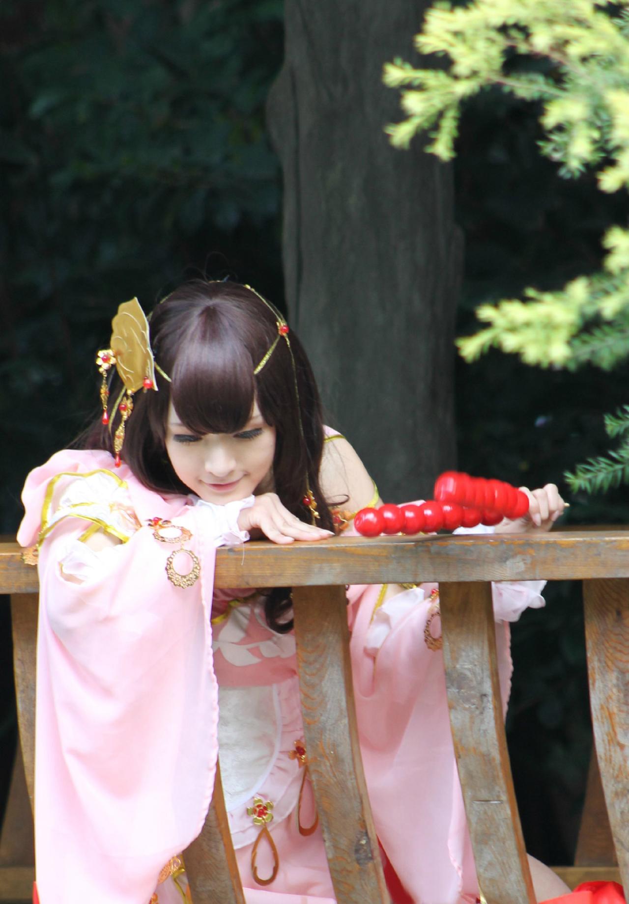 陈小丸扮演定国秀萝拿着两串糖葫芦扒在亭子的围栏上