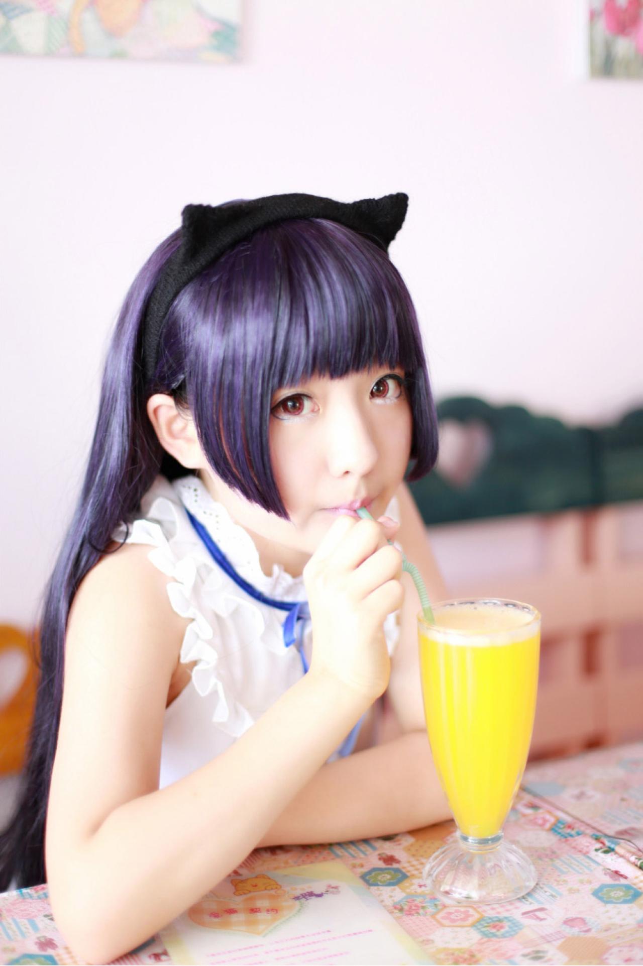 AOI扮演五更琉璃坐在铺有卡通贴纸的餐桌上喝果汁
