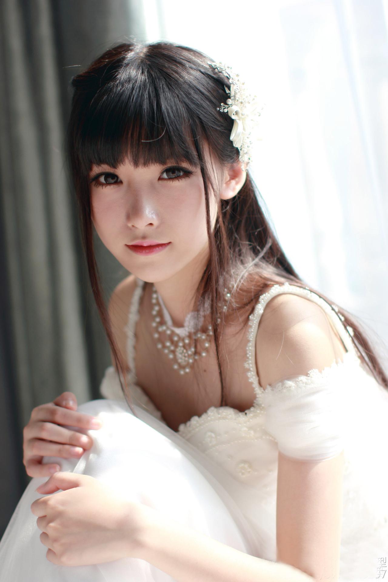 小起扮演新娘坐在窗台抱起膝盖，正脸看镜头