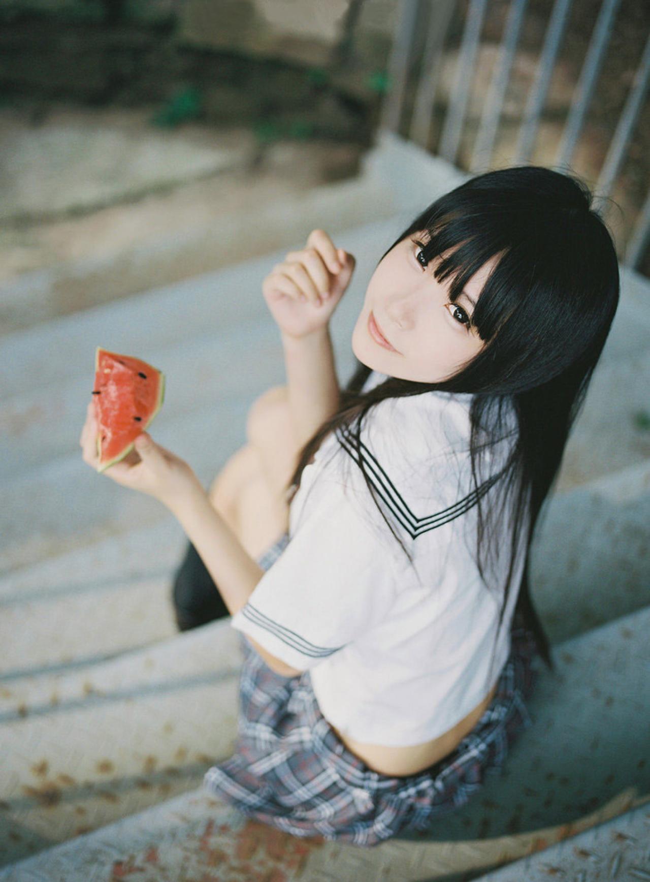 小起拿着一块西瓜坐在台阶上