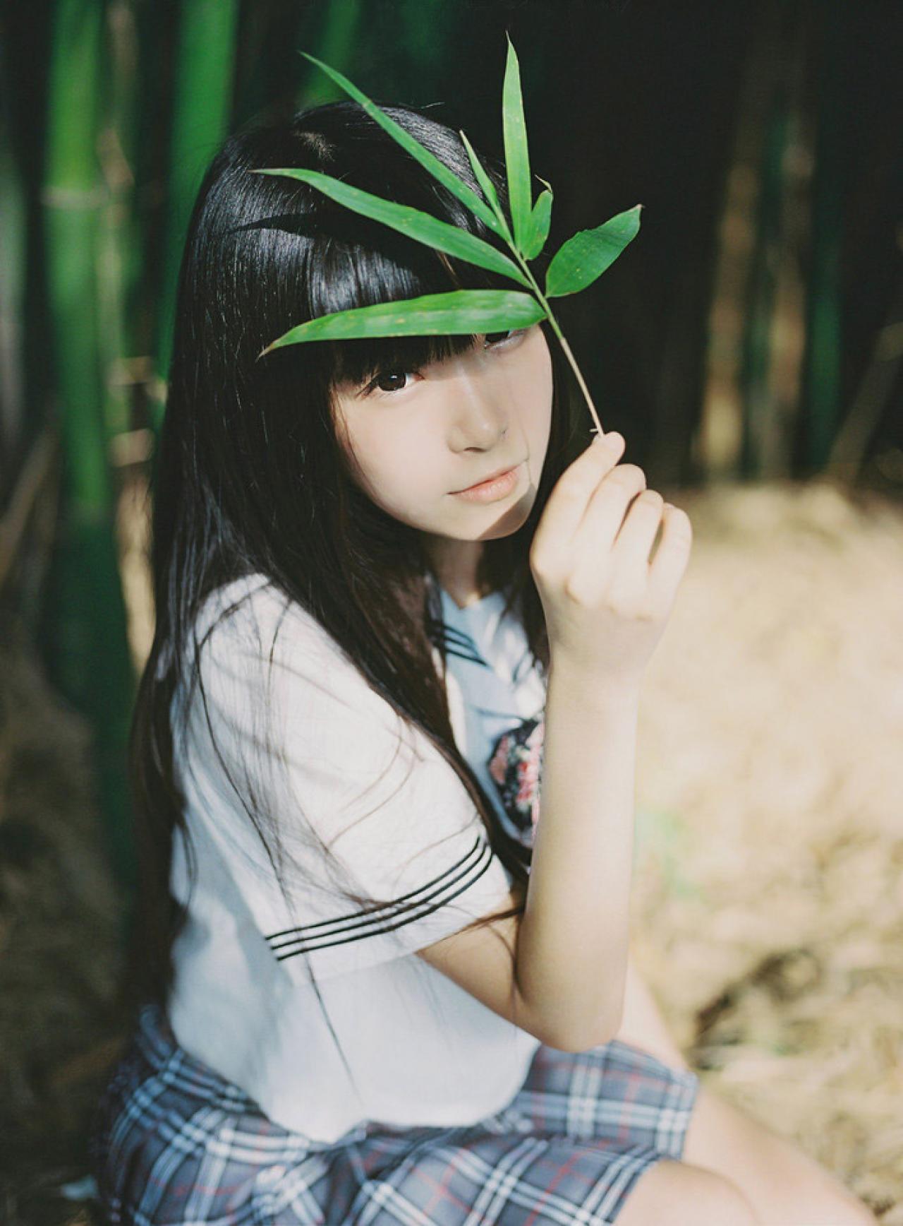 小起捏着一片叶子，放在额头，遮挡阳光。