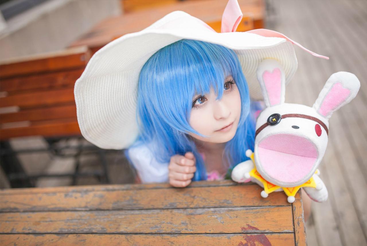 桃小陌扮演四糸乃拿着四糸奈兔子人偶蹲在椅子下，斜视侧面