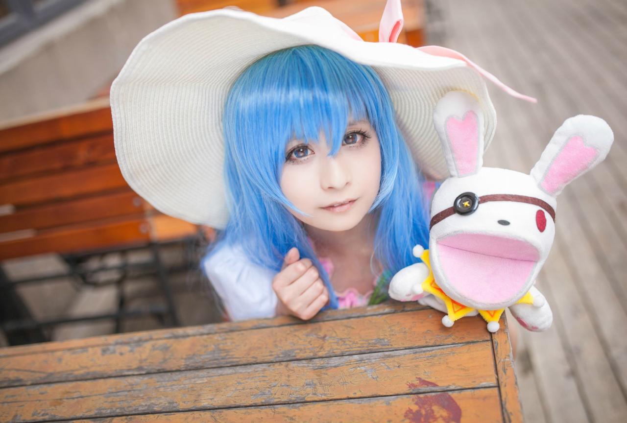 桃小陌扮演四糸乃拿着四糸奈兔子人偶蹲在椅子旁，看着镜头