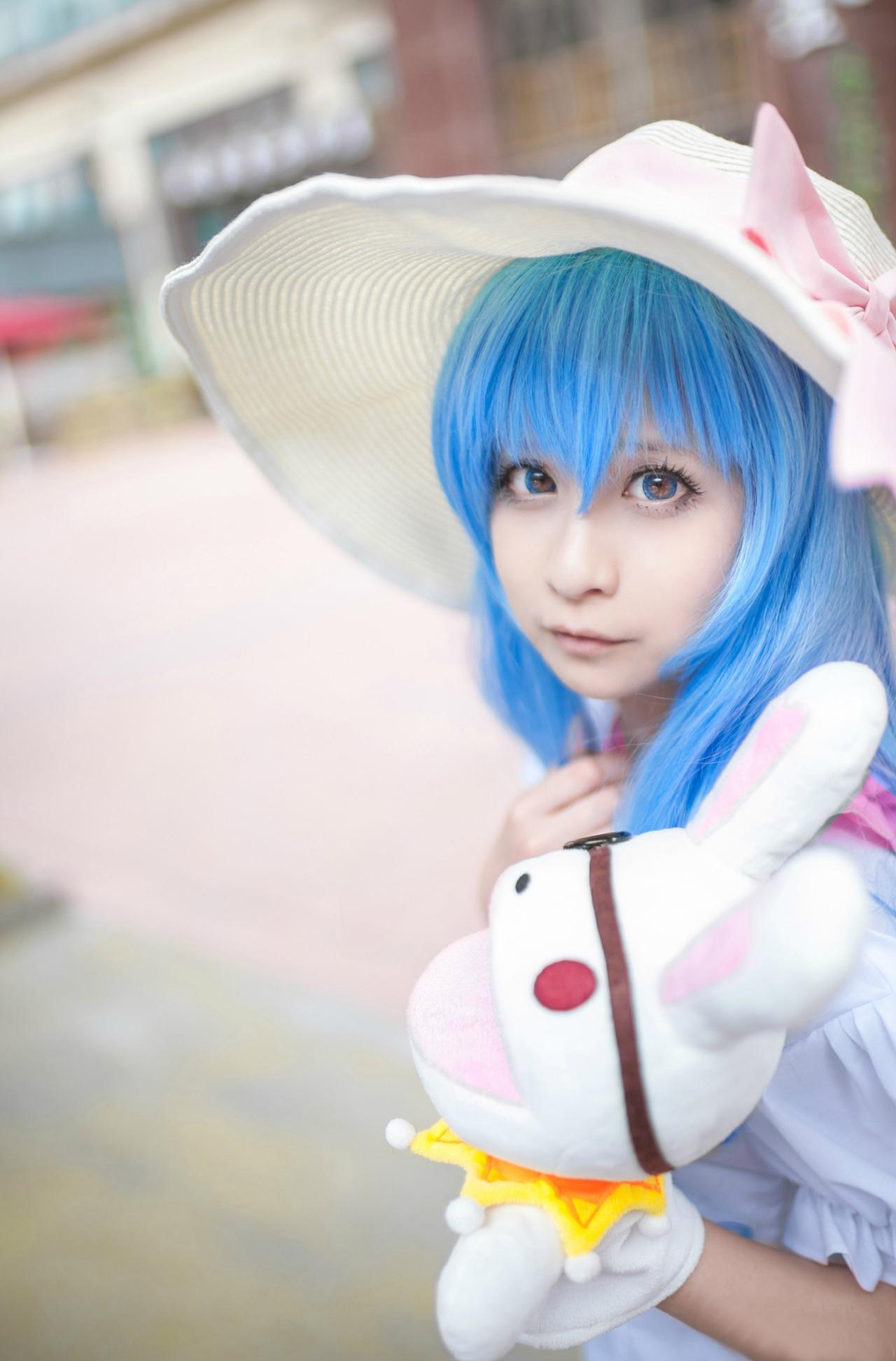 桃小陌扮演四糸乃拿着四糸奈兔子人偶走在街上，侧面照