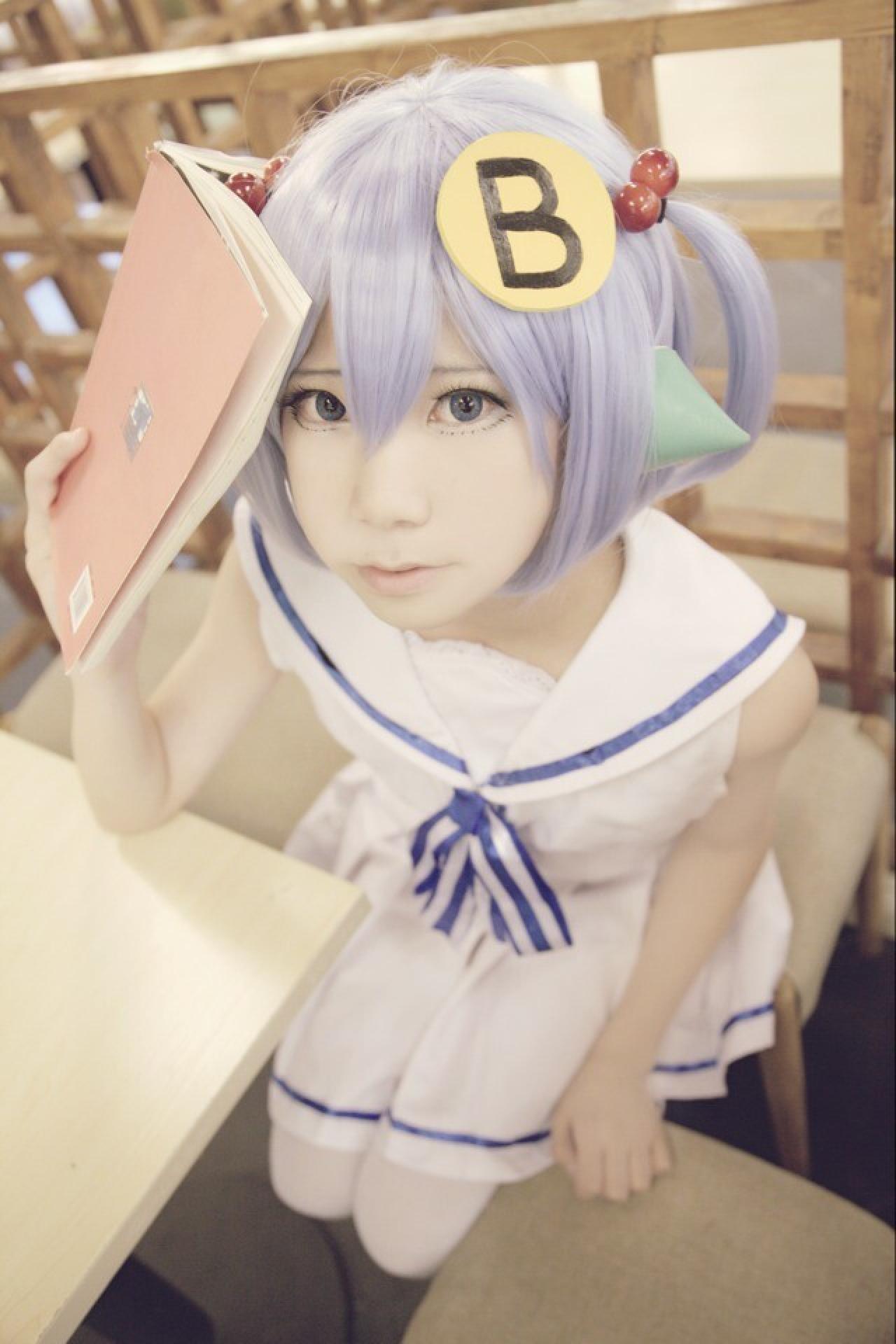 柒君扮演林小B跪坐在桌子旁，拿着一本书