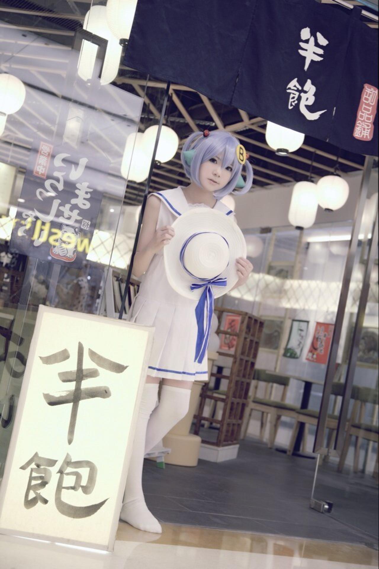 柒君扮演林小B站在半饱日式甜品店门口，门前立着半饱的毛笔字招牌