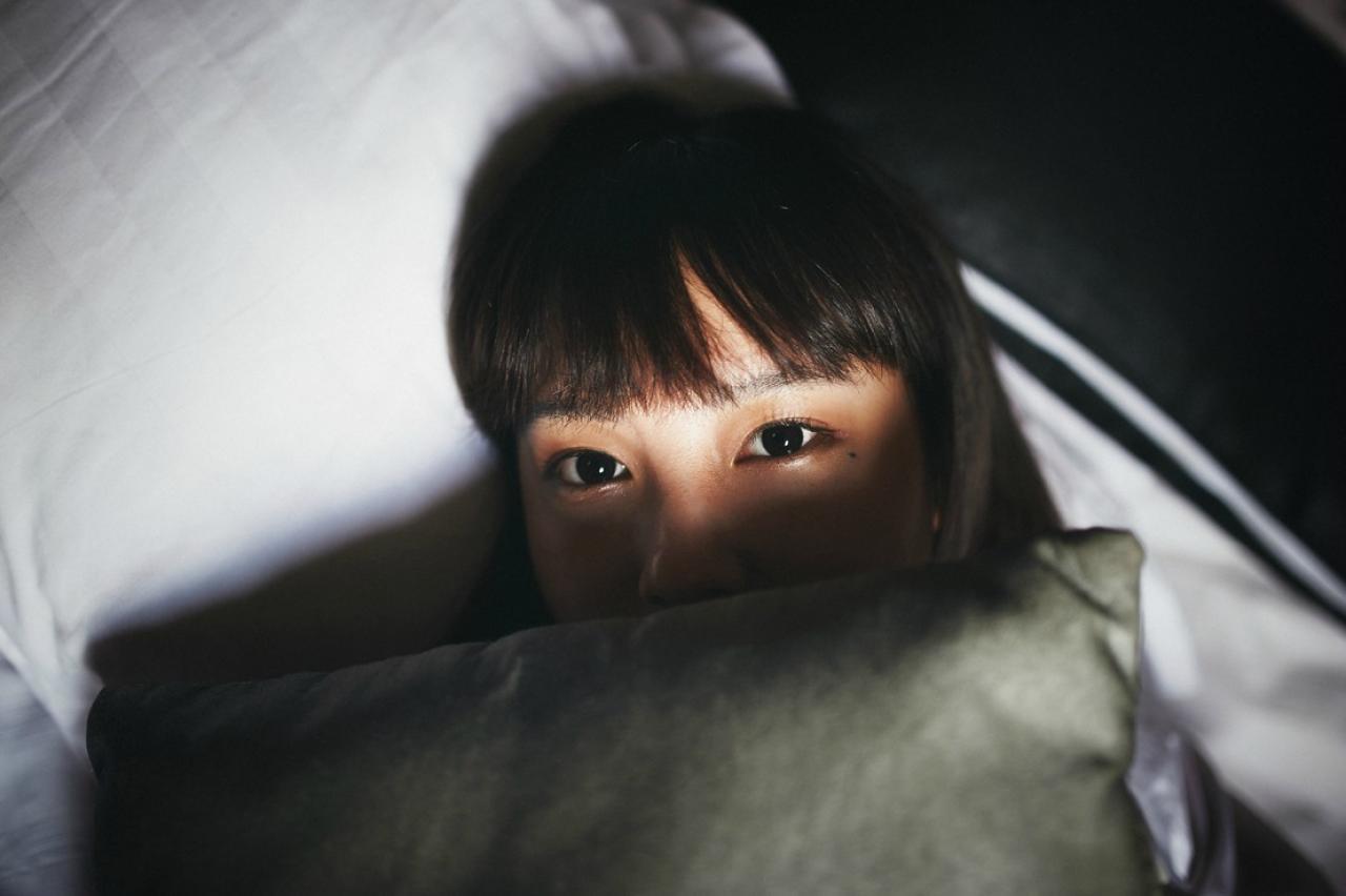 山田実瑠_抱着绿色枕头躺在床上，用枕头遮住嘴