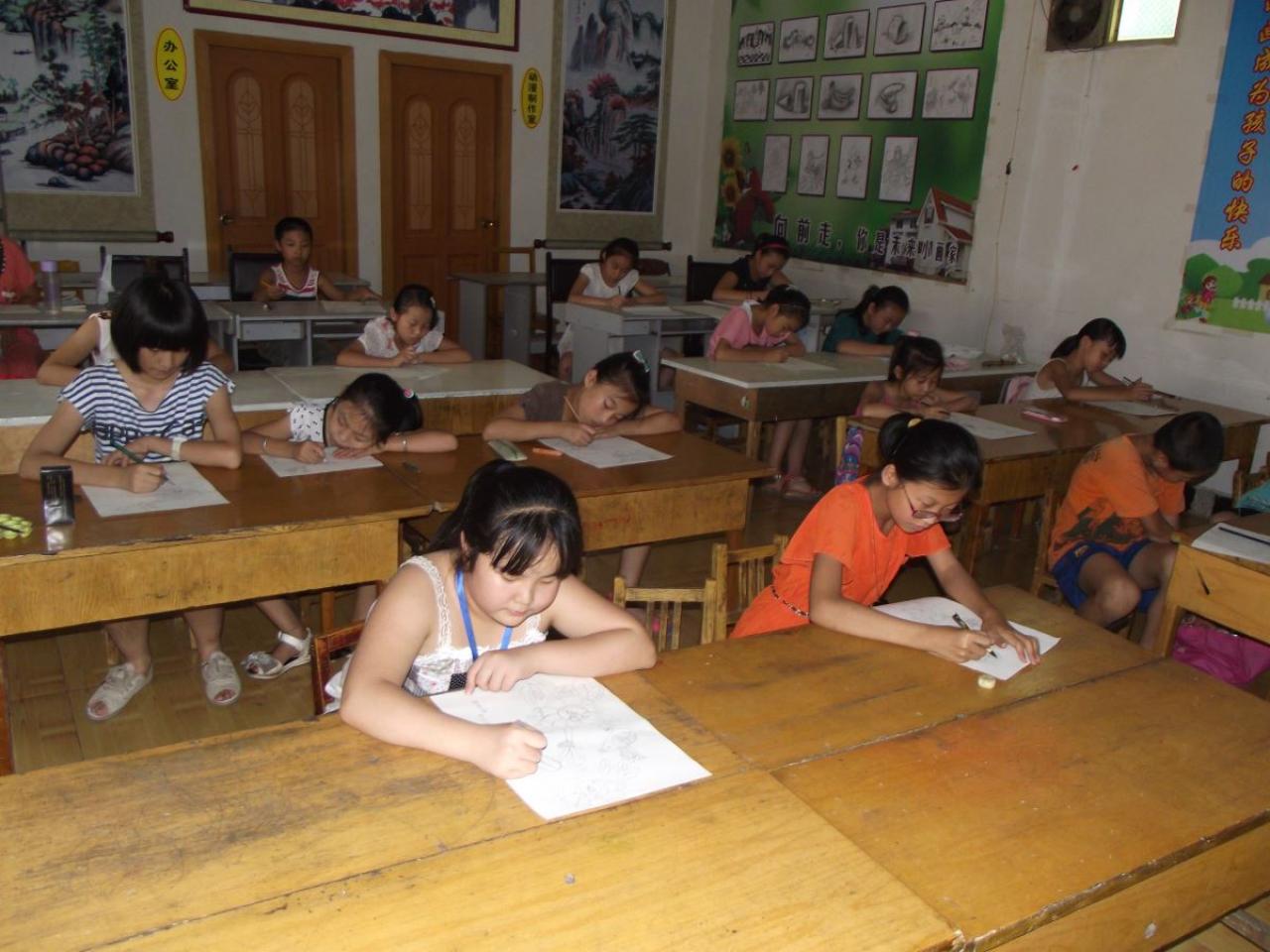 圆梦画室中级班学生扒在桌子上认真绘制白描稿的样子