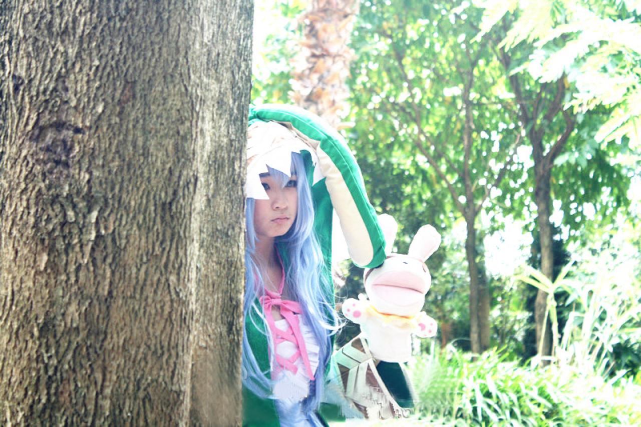 阡陌扮演四糸乃藏在树后，嘟嘴卖萌的样子