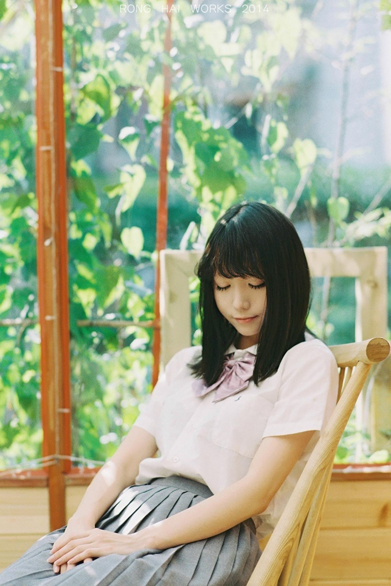 Meter闭眼安静的躺在躺椅上，背景是满窗的绿色藤曼