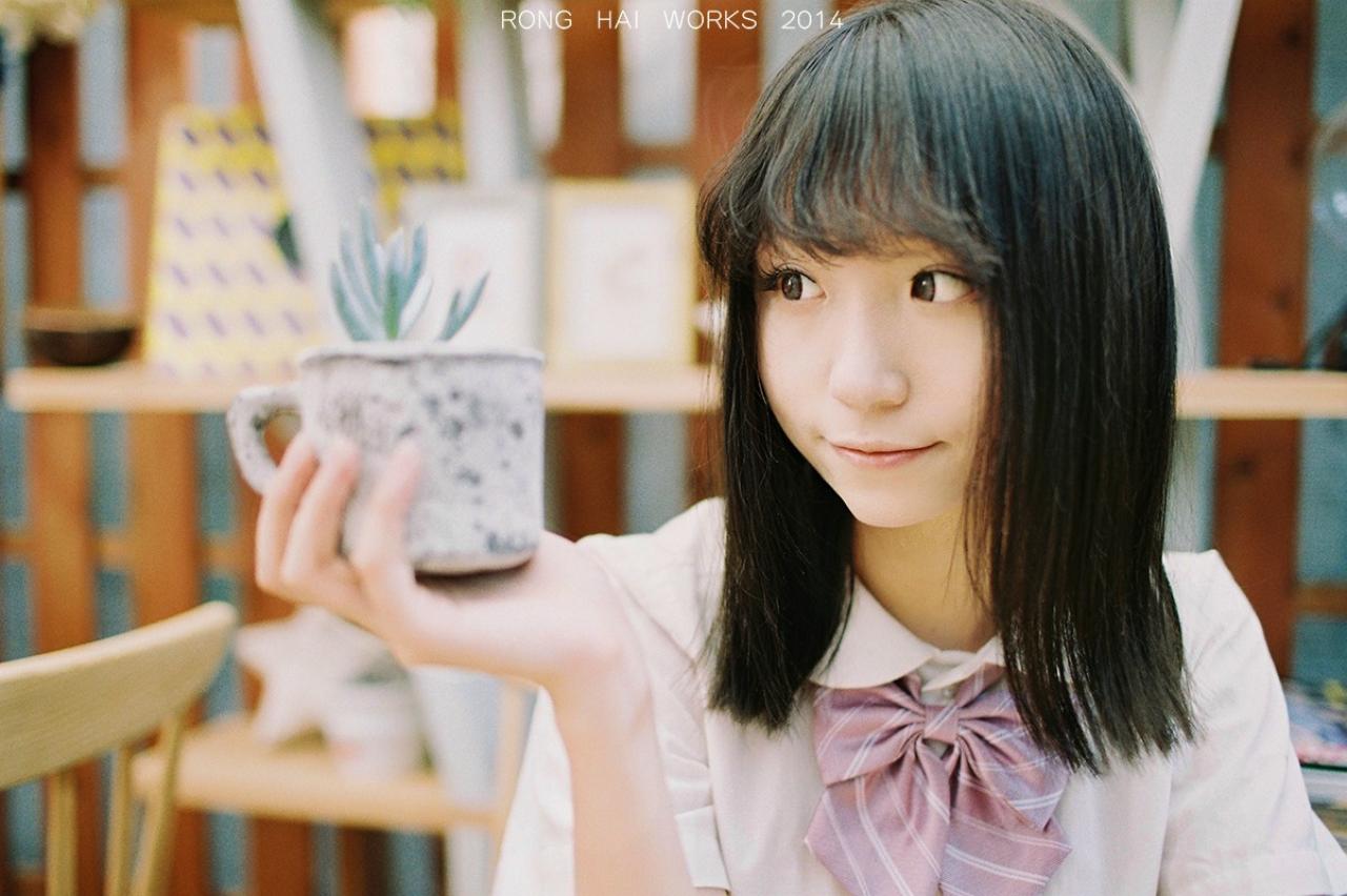 Meter坐在椅子上，手里拿着一盆盆栽，眼睛斜斜的看向窗外