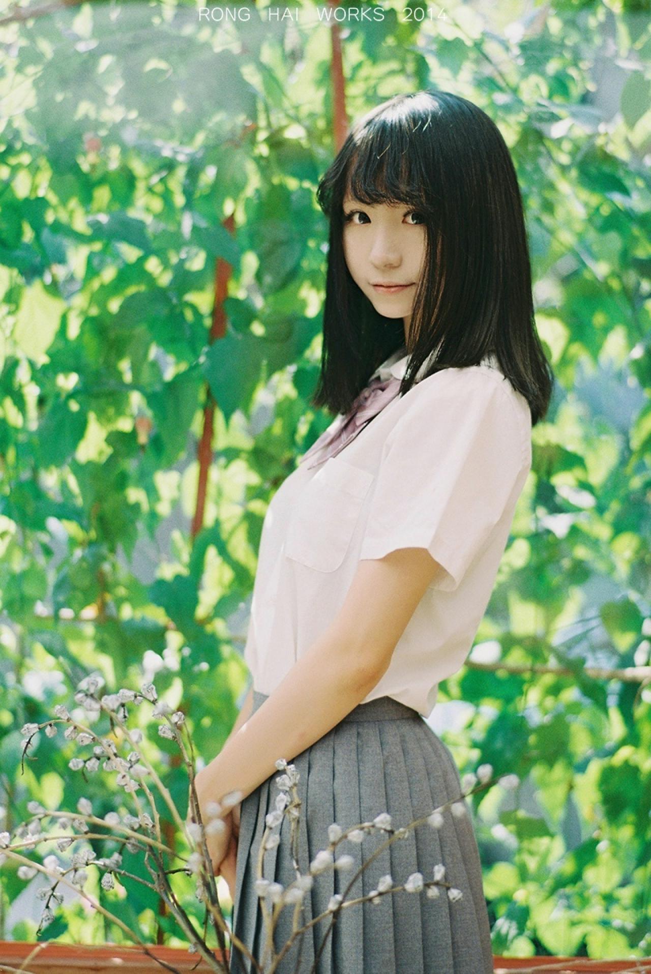 Meter侧身站在绿色藤曼前，头看向镜头