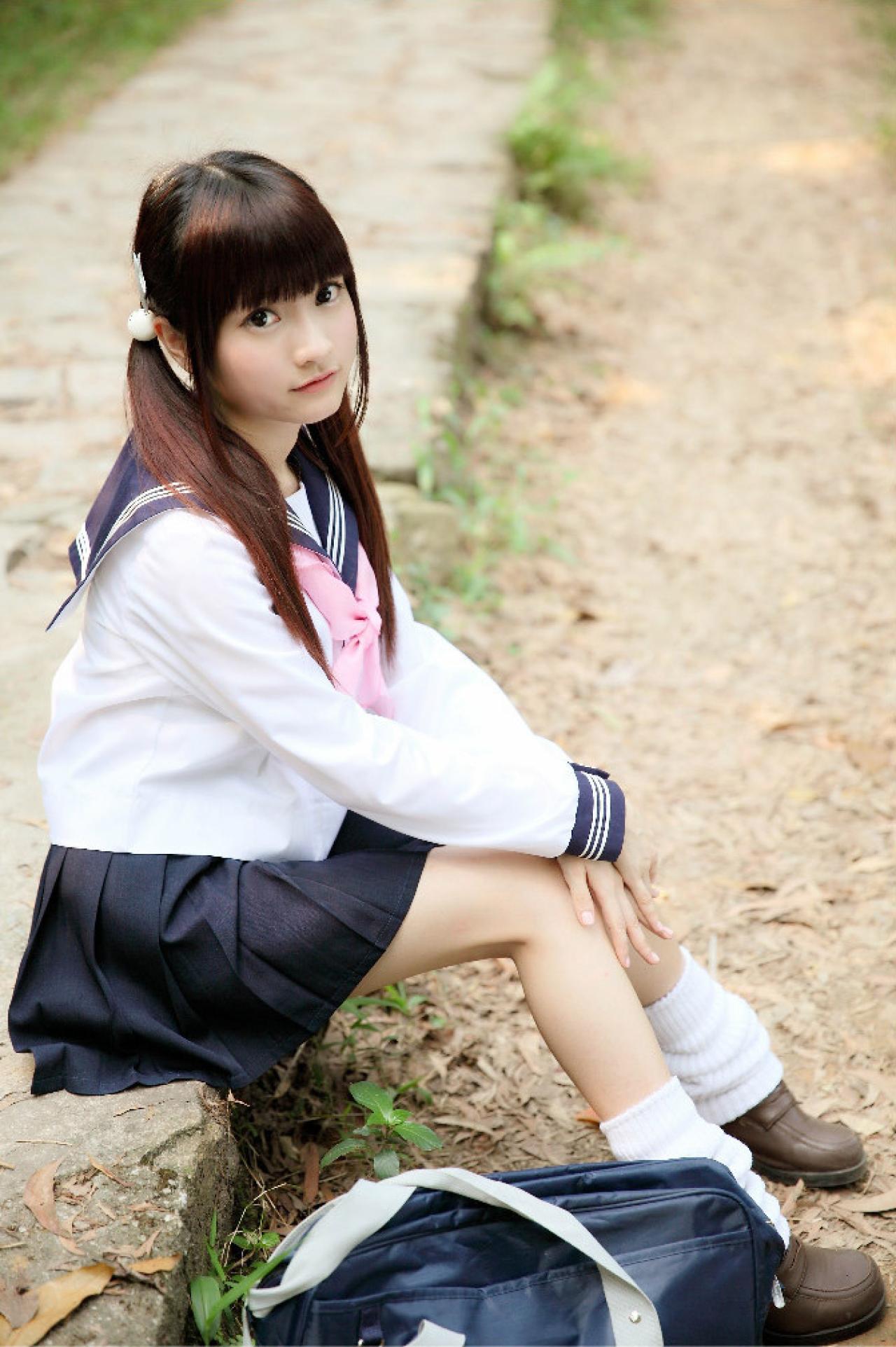 橘子酱穿着水手服坐在道路旁的台阶上