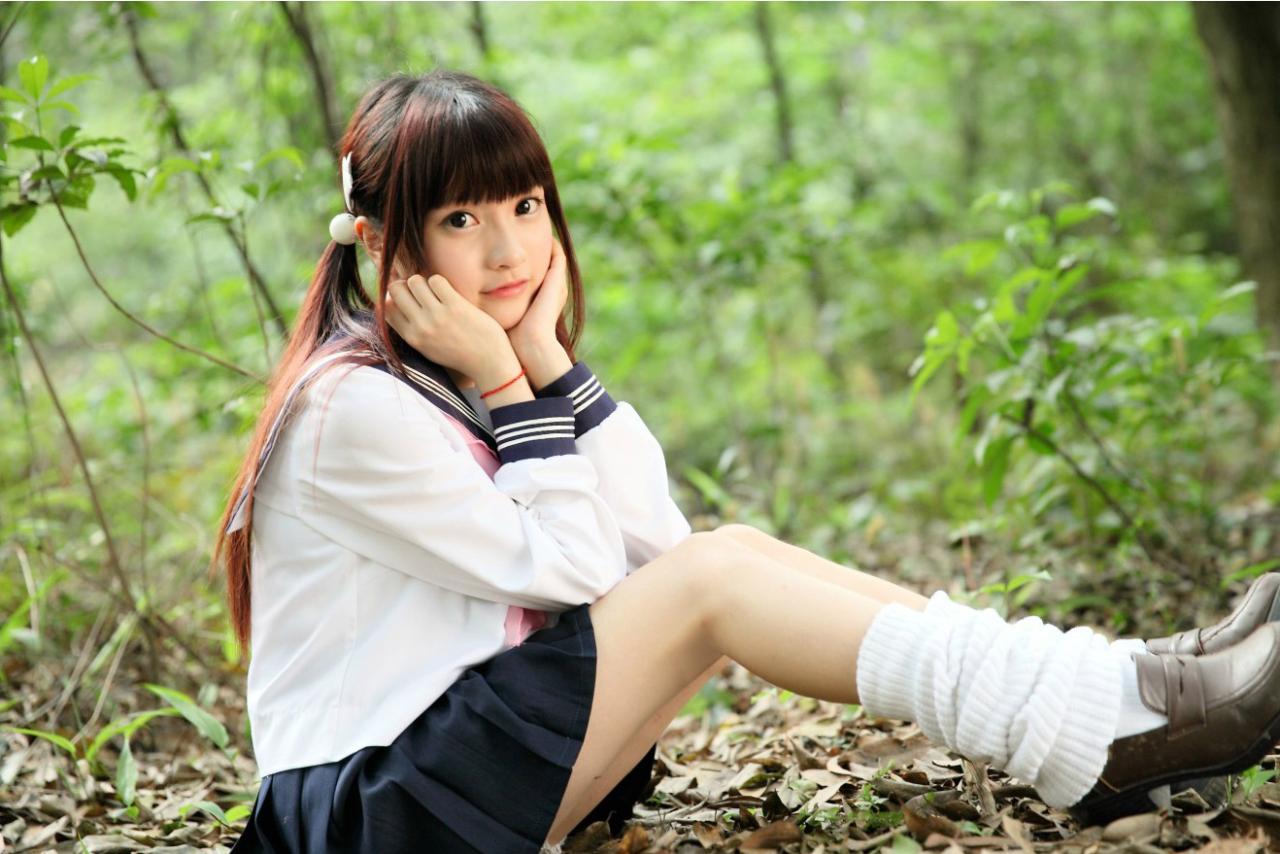 橘子酱穿着水手服神长腿坐在地上，双手捧着脸