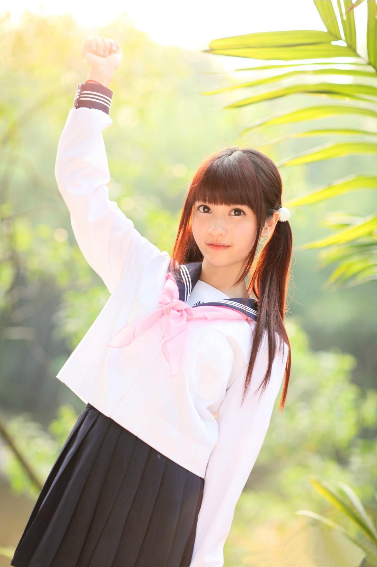 橘子酱穿着水手服一只手抬起，顶着阳光的姿势