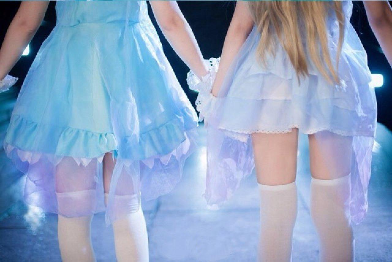 織田桑饰演矢泽妮可和灰子扮演南小鸟在舞台上面向观众席手牵手的背景